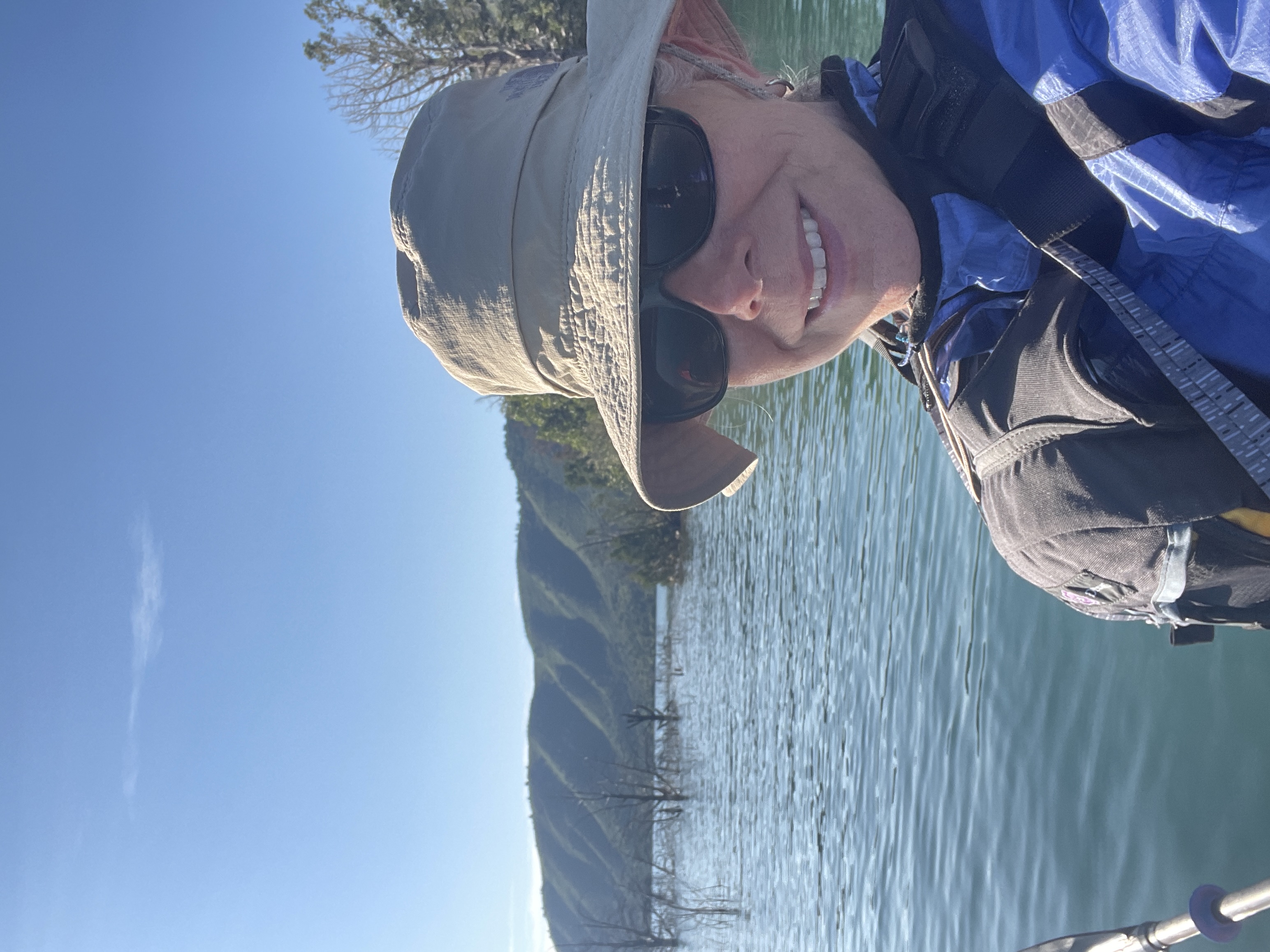 woman wearing hat, sunglasses and life jacket while engaging in water sports