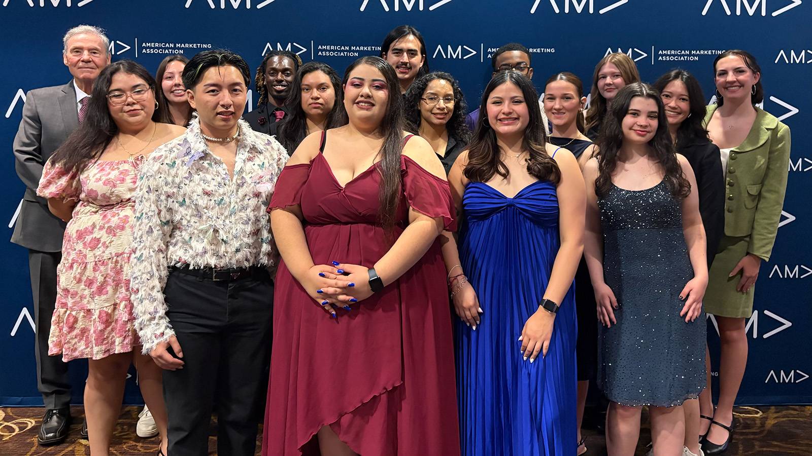 group of formally dressed people pose for photo at the AMA awards