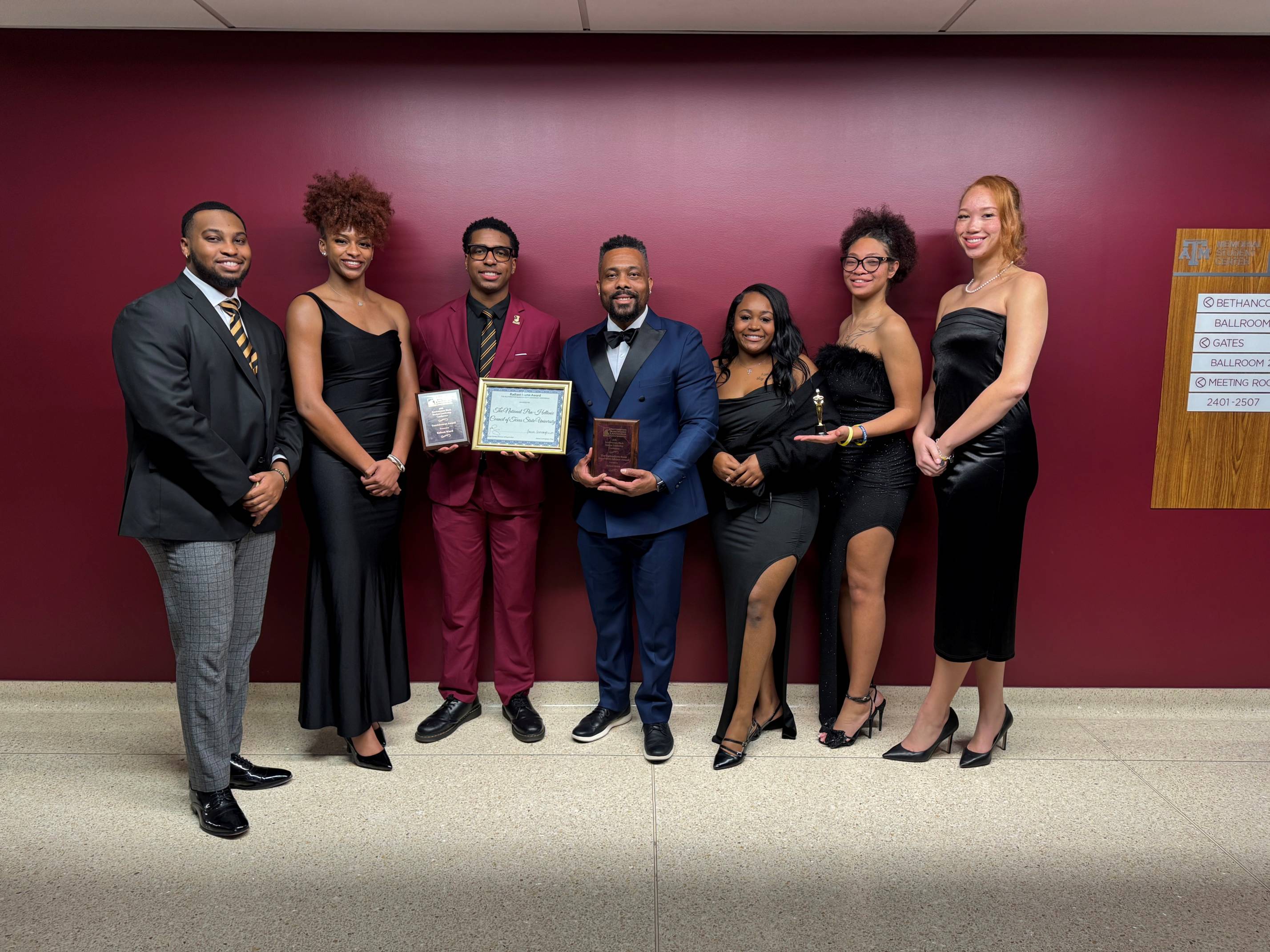 Students and advisor posing with awards