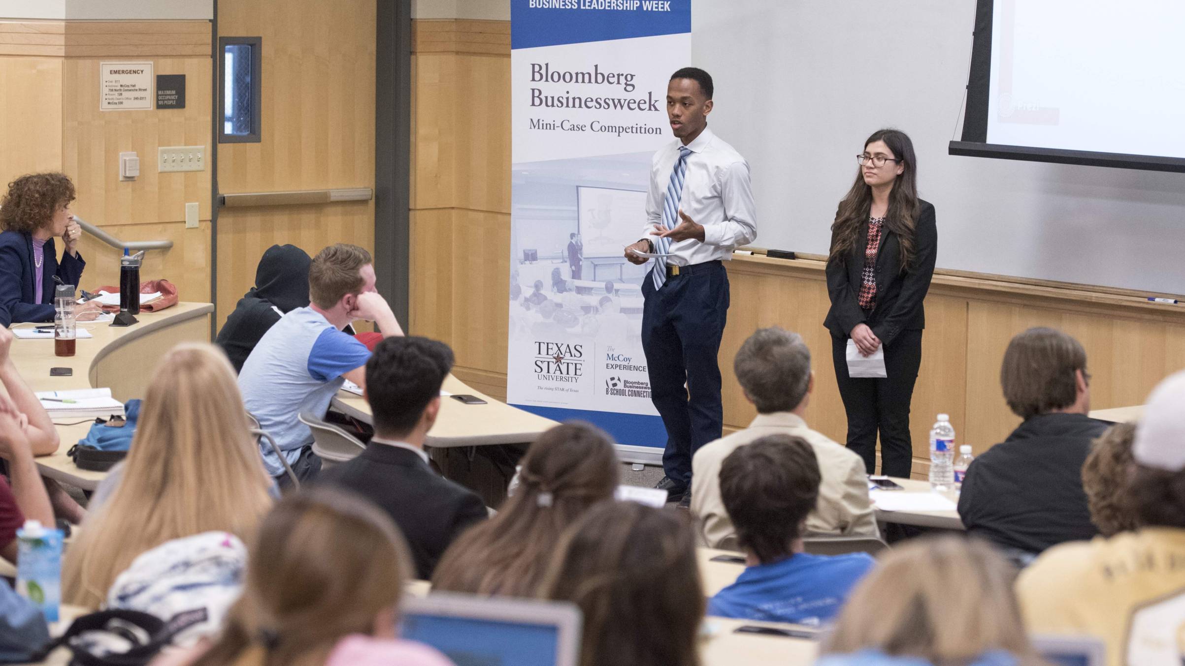 Two presenters in front of a class