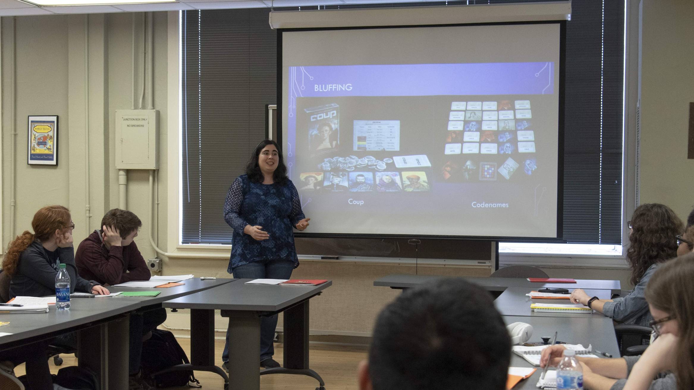 teacher at the front of a class with a PowerPoint