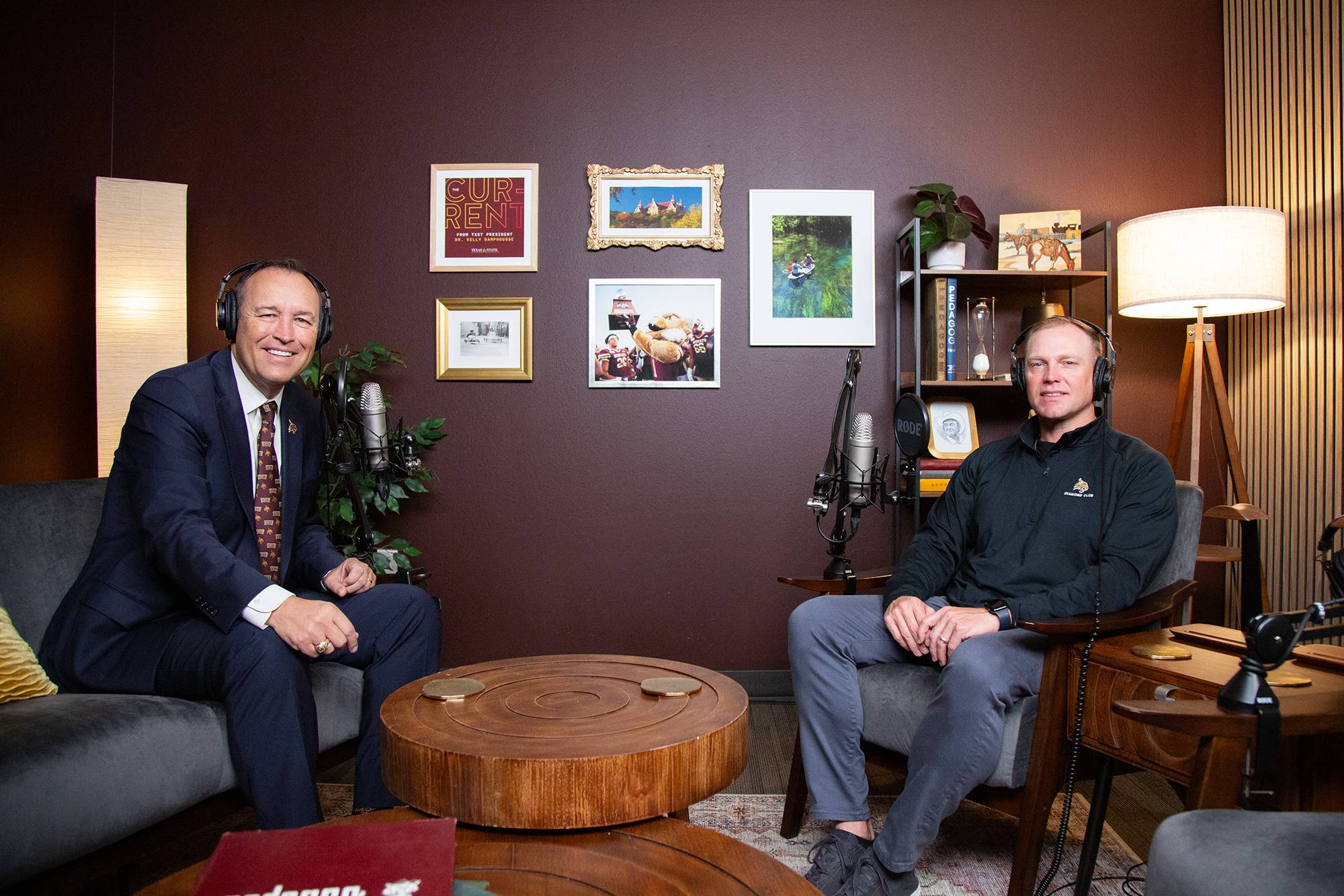two men sit in podcast studio and pose for a photo together