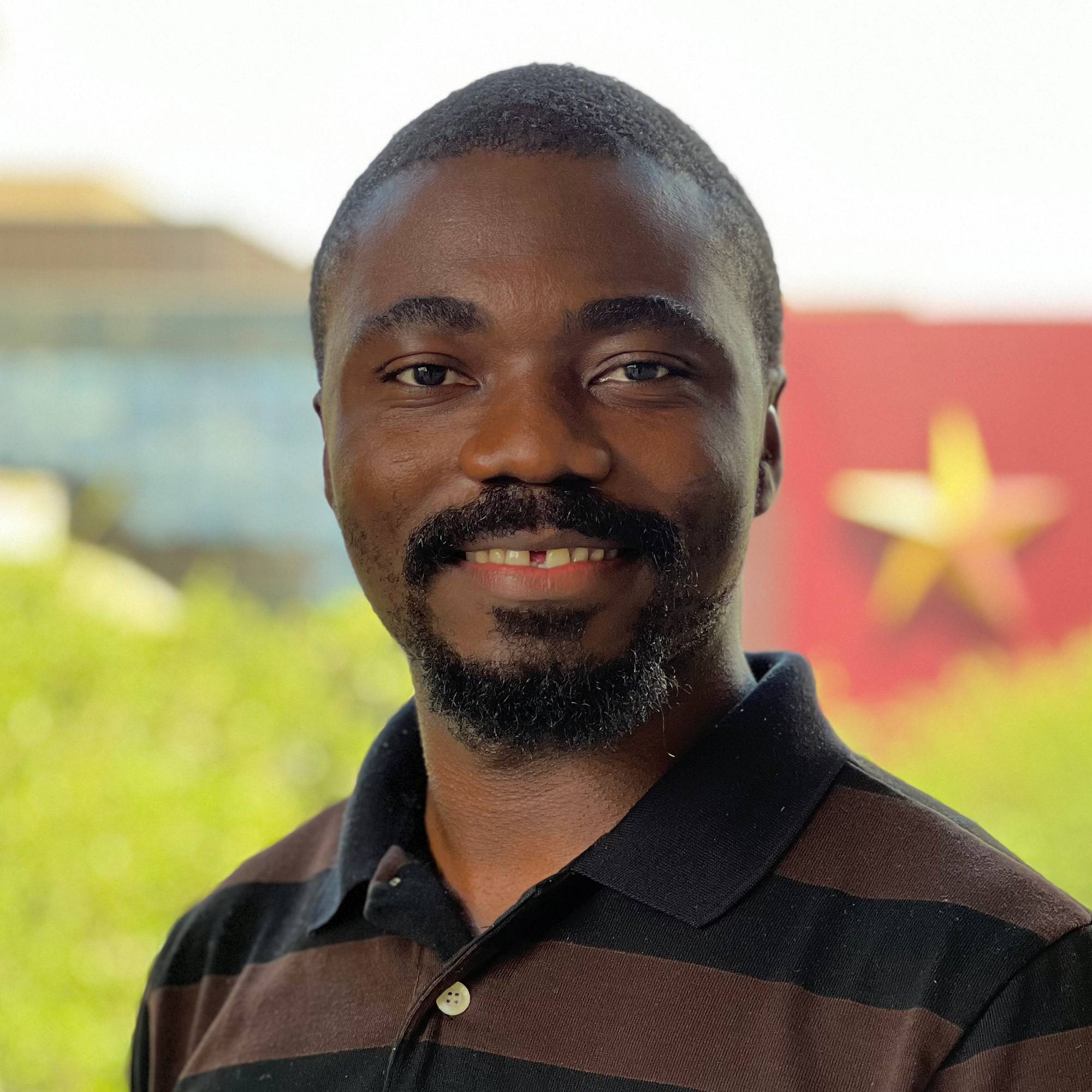 Augustine Tarkom posing in front of scenic background