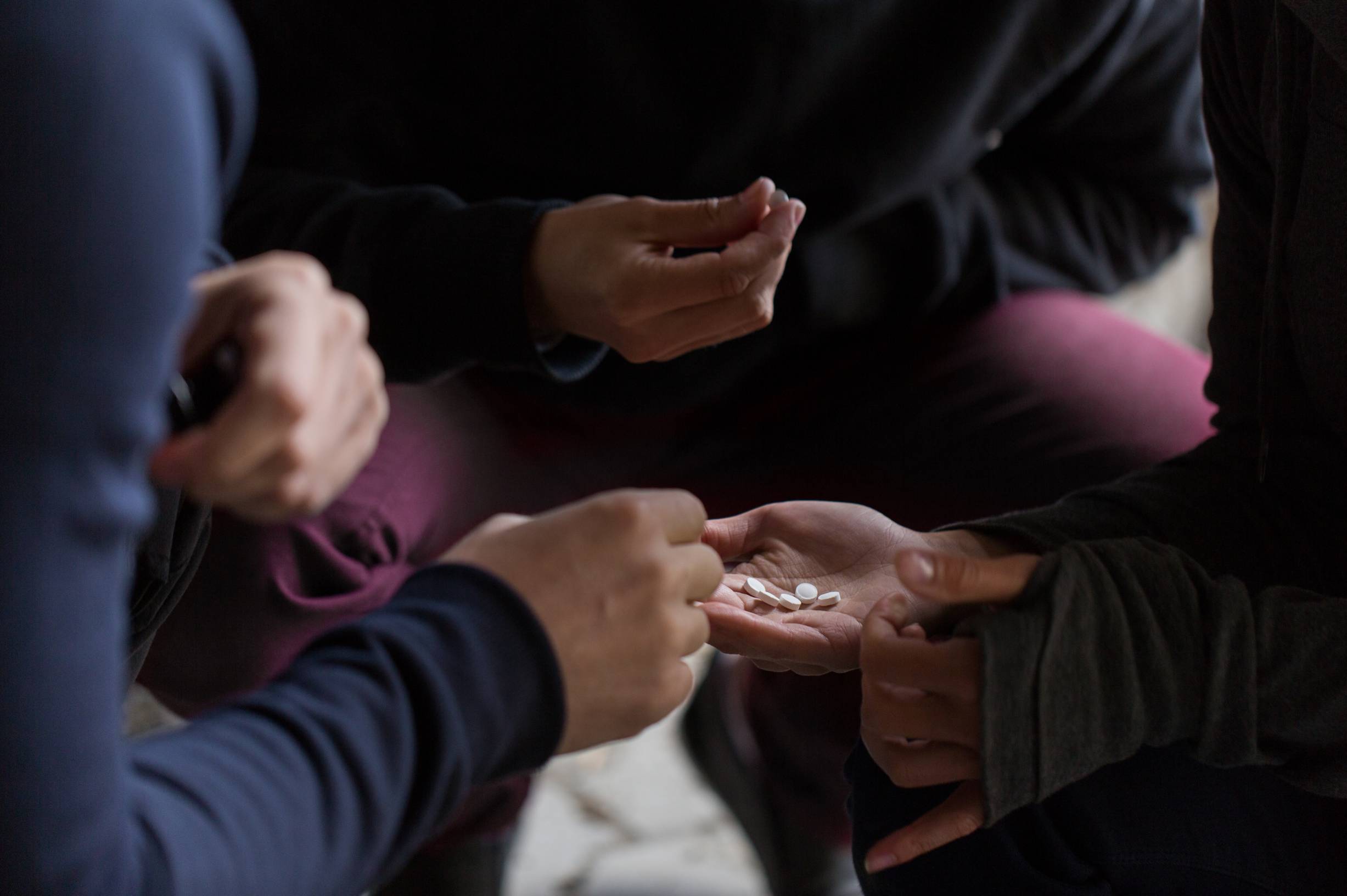 Pills being passed between hands