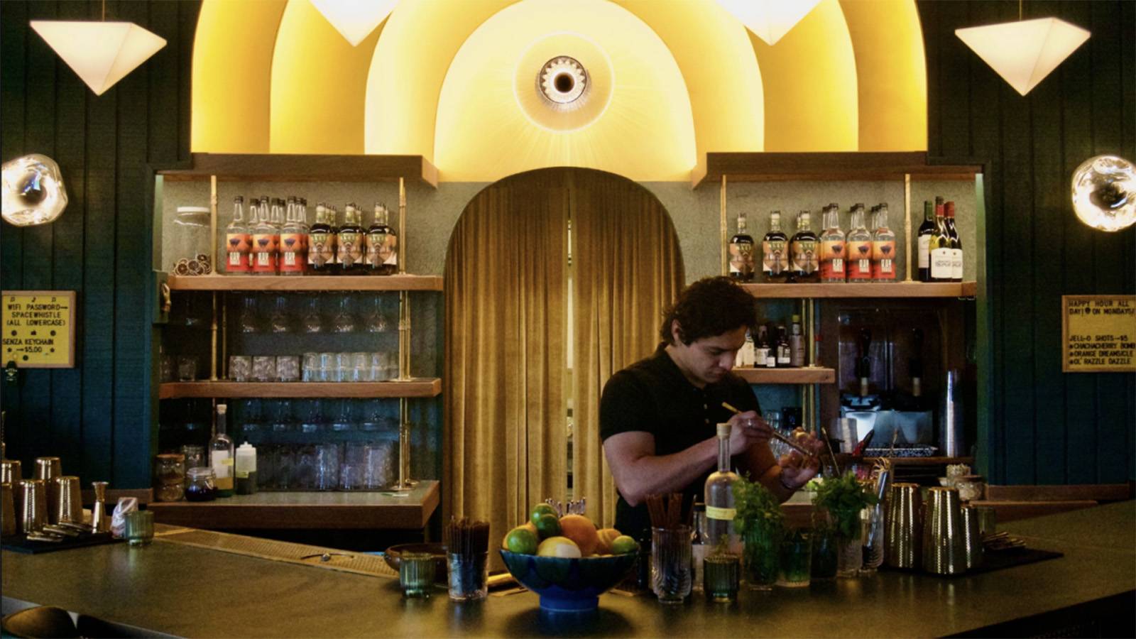 male bartender making a drink behind the bar
