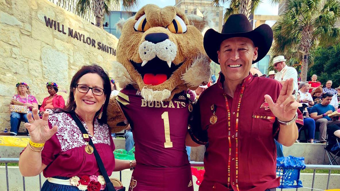 First Lady Beth Damphousse (left), Boko, and President Kelly Damphousse pose for a photo at the River Walk.