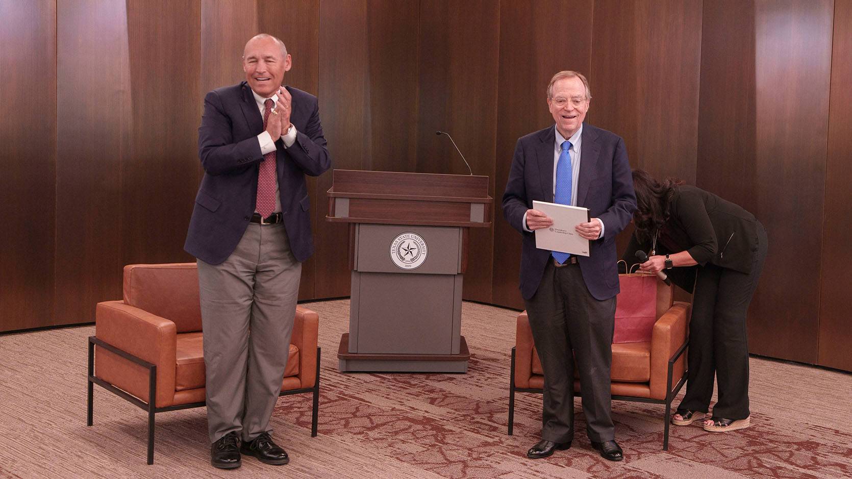 President Kelly Damphousse (left) speaks to an audience with Jack Martin by his side.