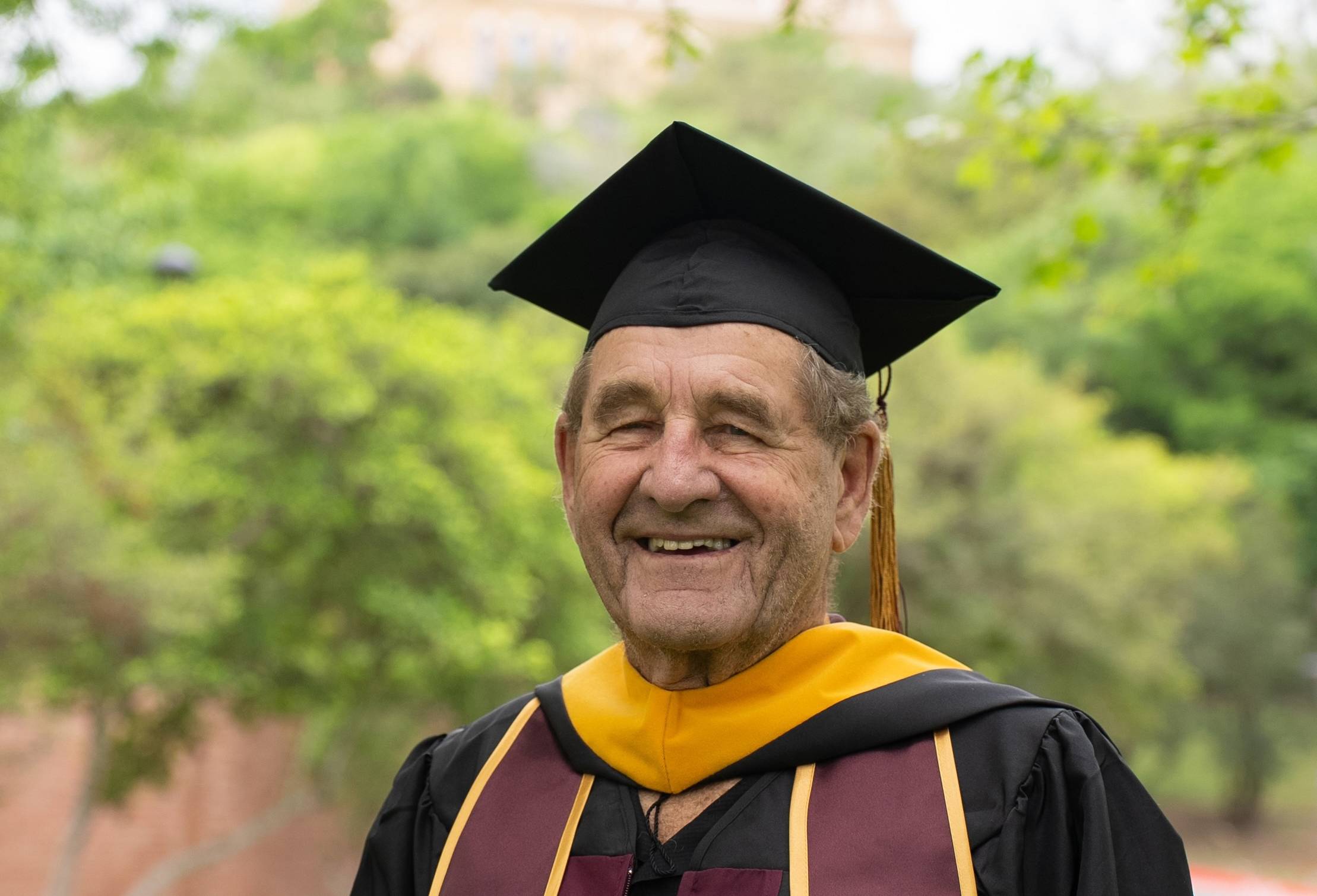 older man wearing graduation regalia 
