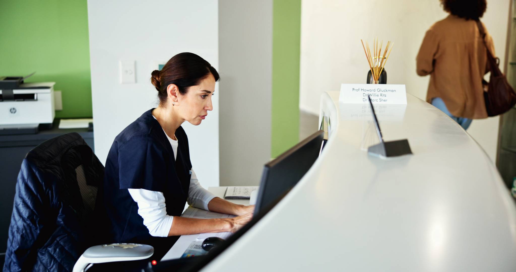 Receptionist filling out paperwork.