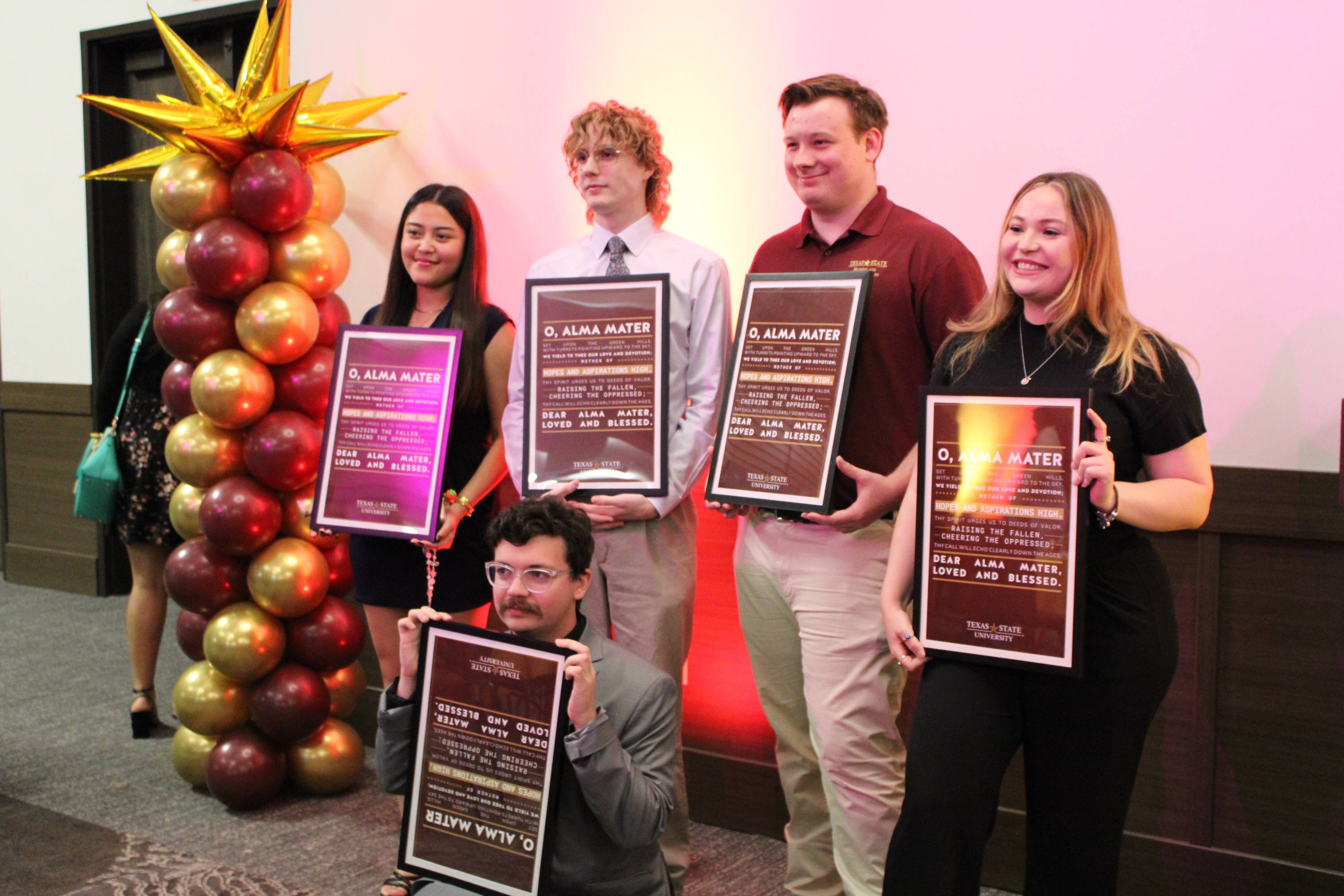 Five students holding a poster 