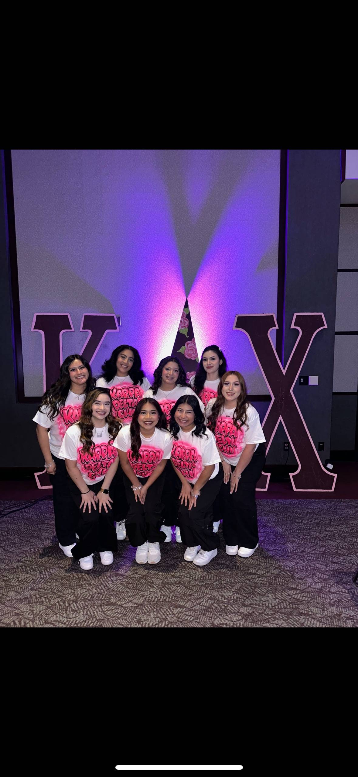 Sorority women posing in front of letters