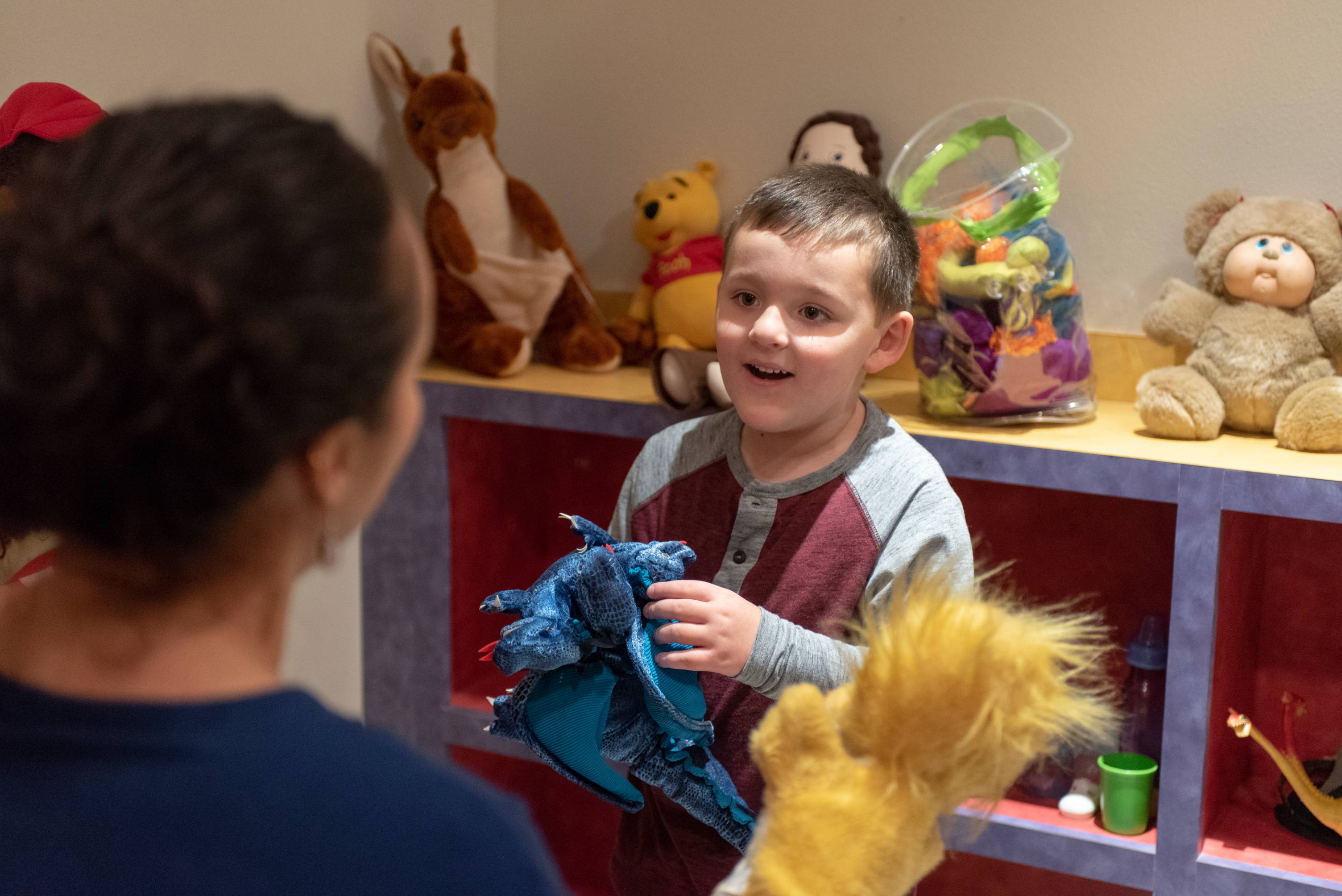 play therapist and child playing puppets