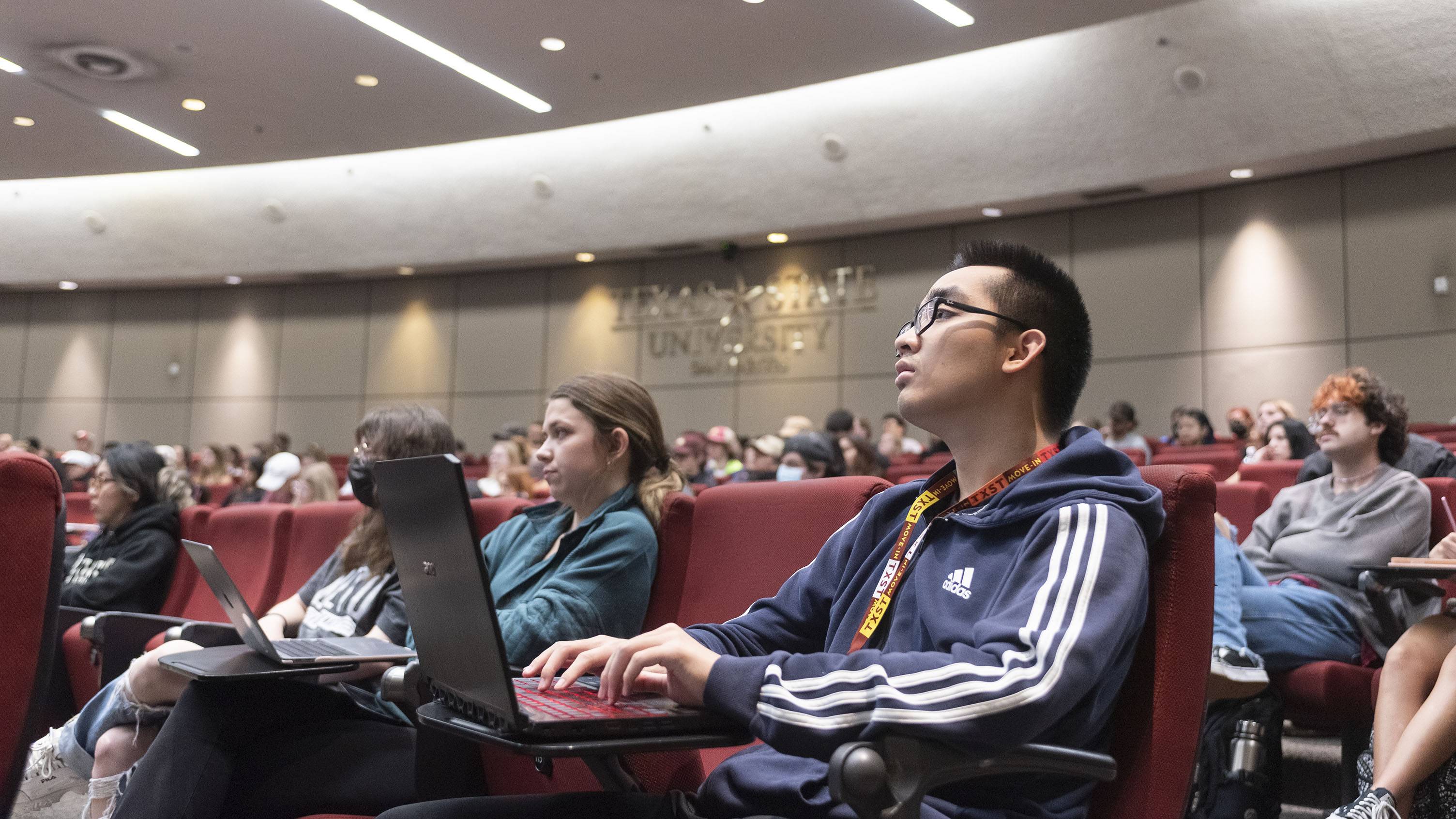 Students listen to a presentation in a classroom.
