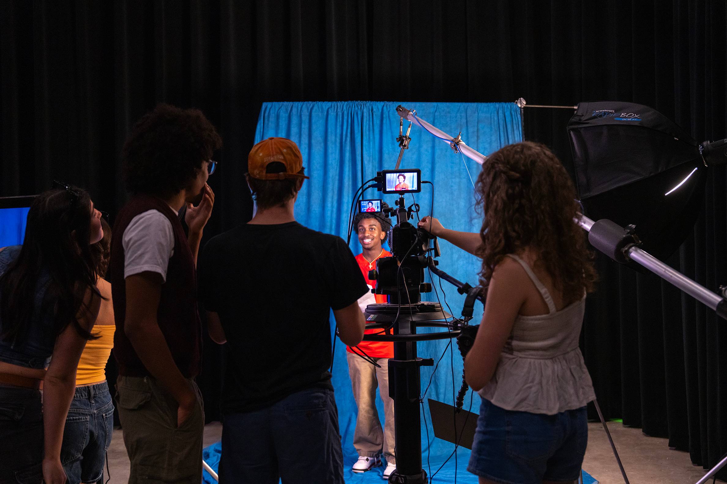 multiple students watch an actor in a film studio