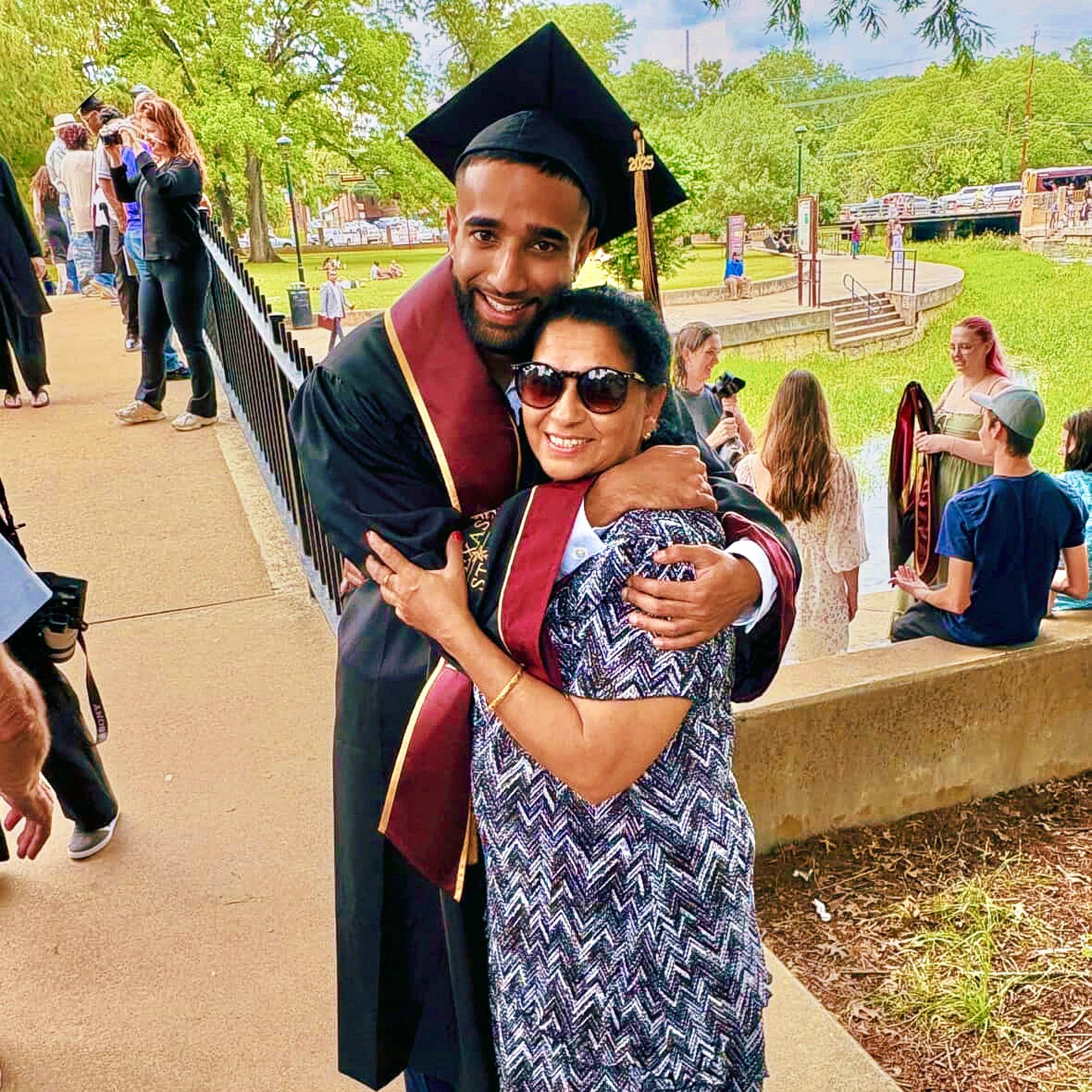 Tim George in graduation robes hugging his mother