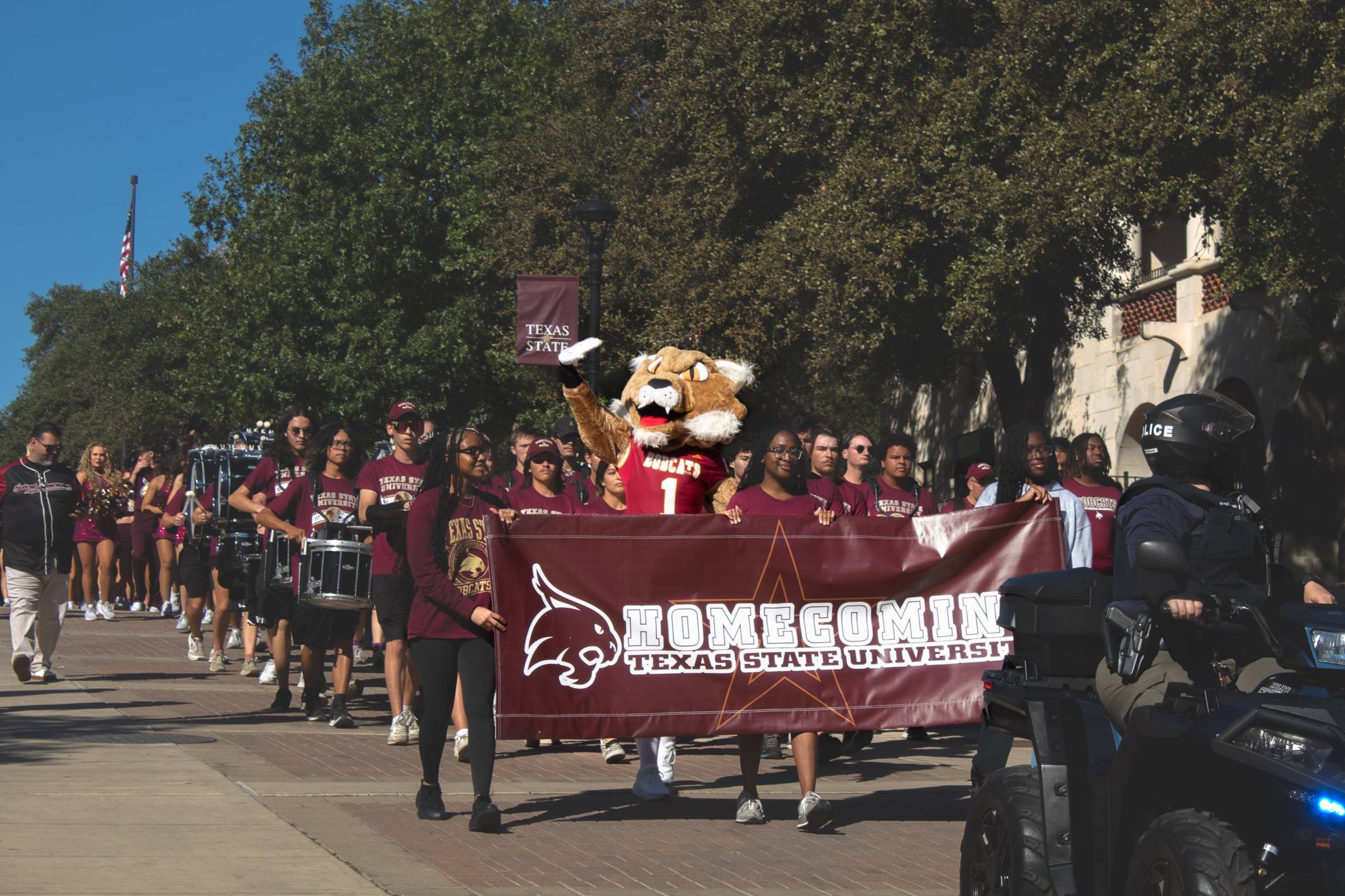 Student cheering behind Boko with outstretched arms
