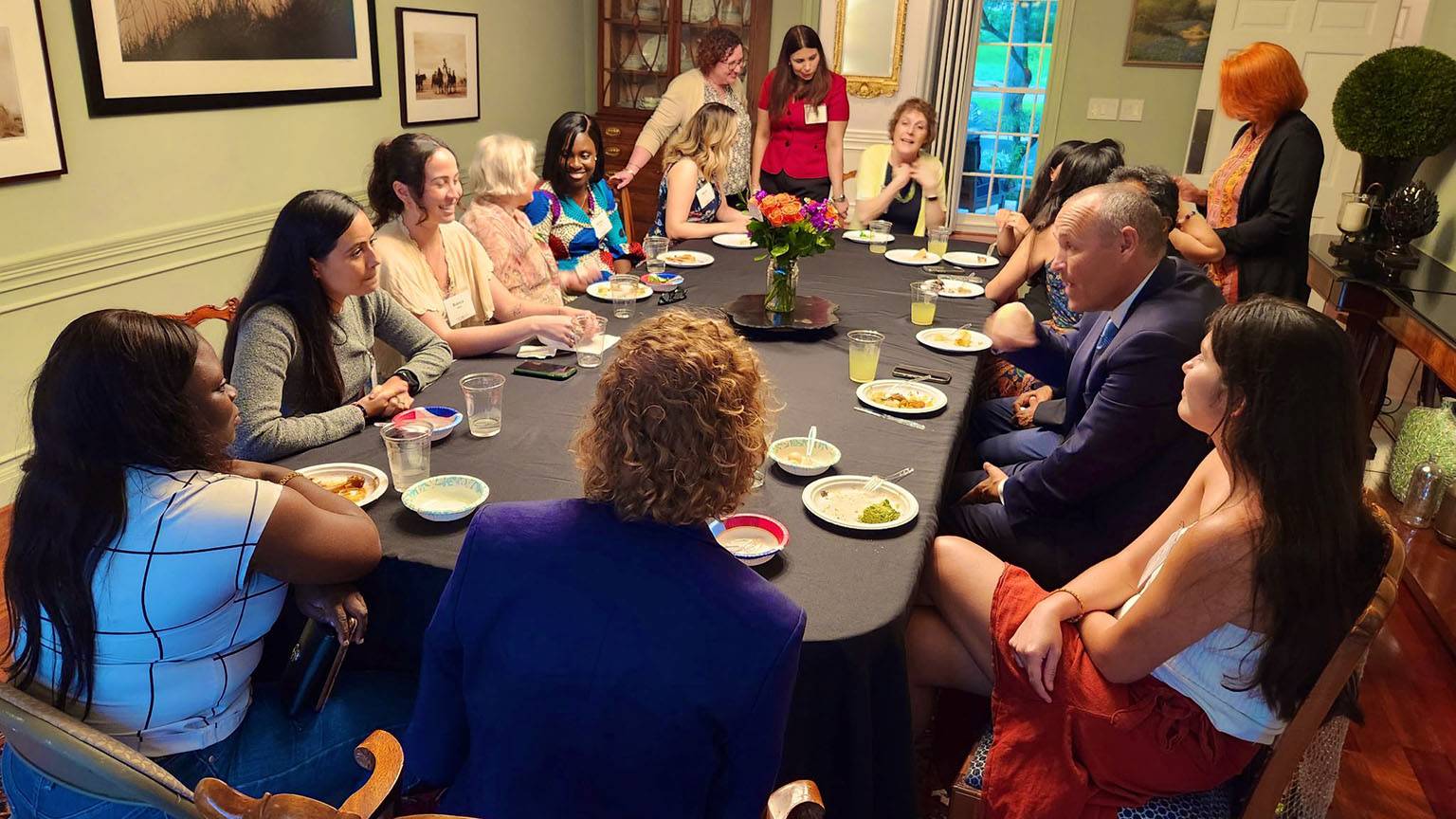 President Kelly Damphouse (middle right) speaks to students at a dinner table.