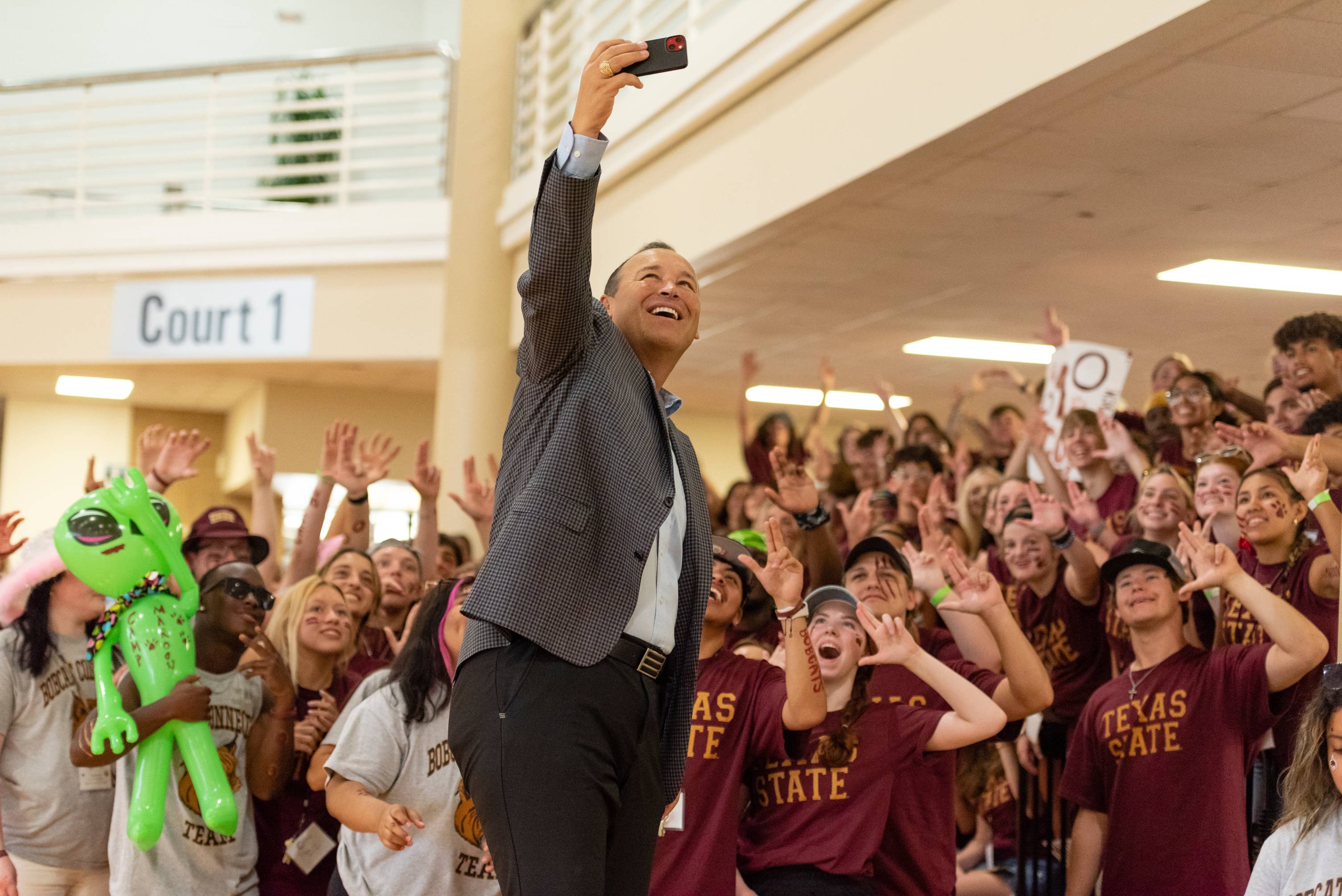 Student cheering behind Boko with outstretched arms