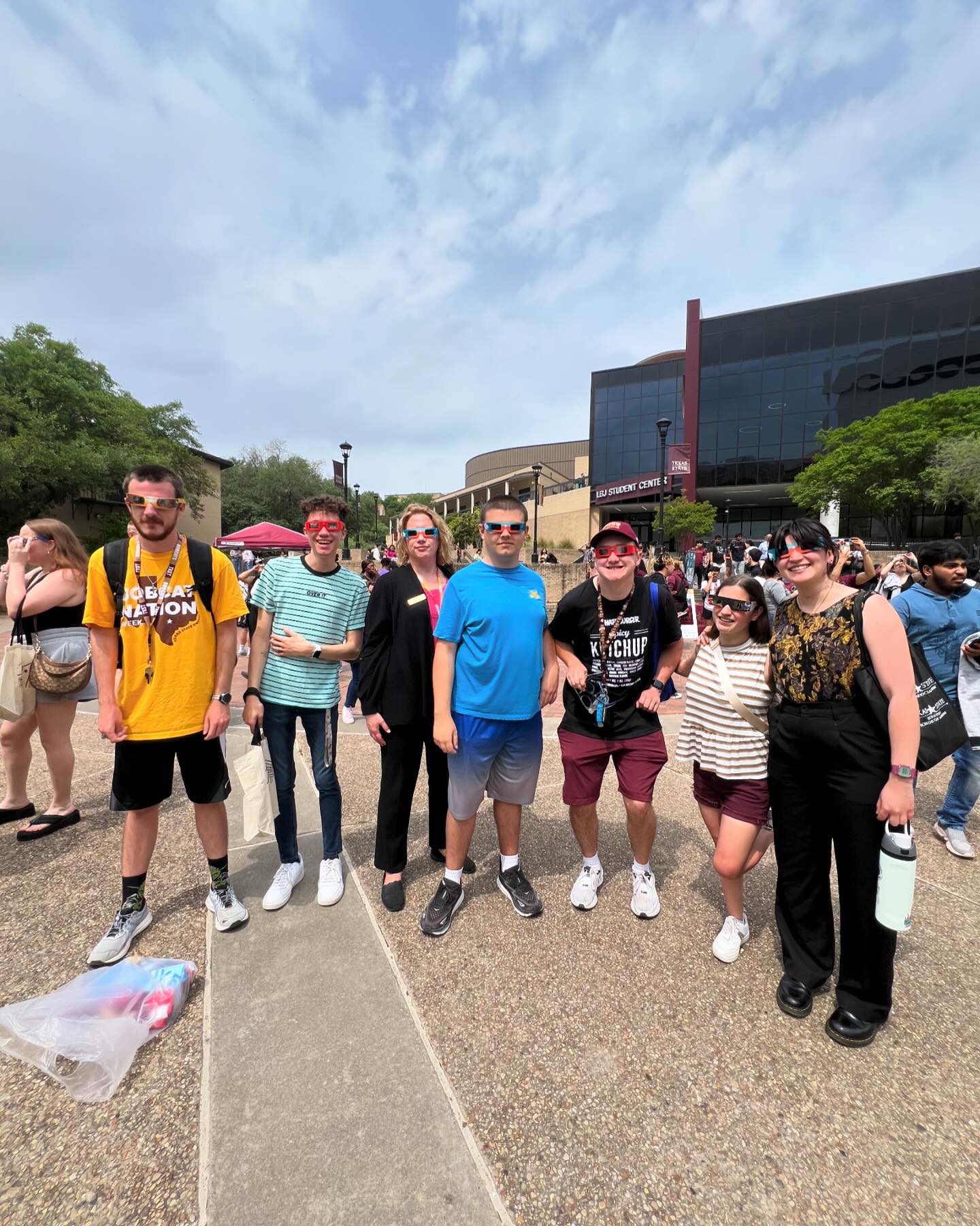 large group of people posing outside on txst campus