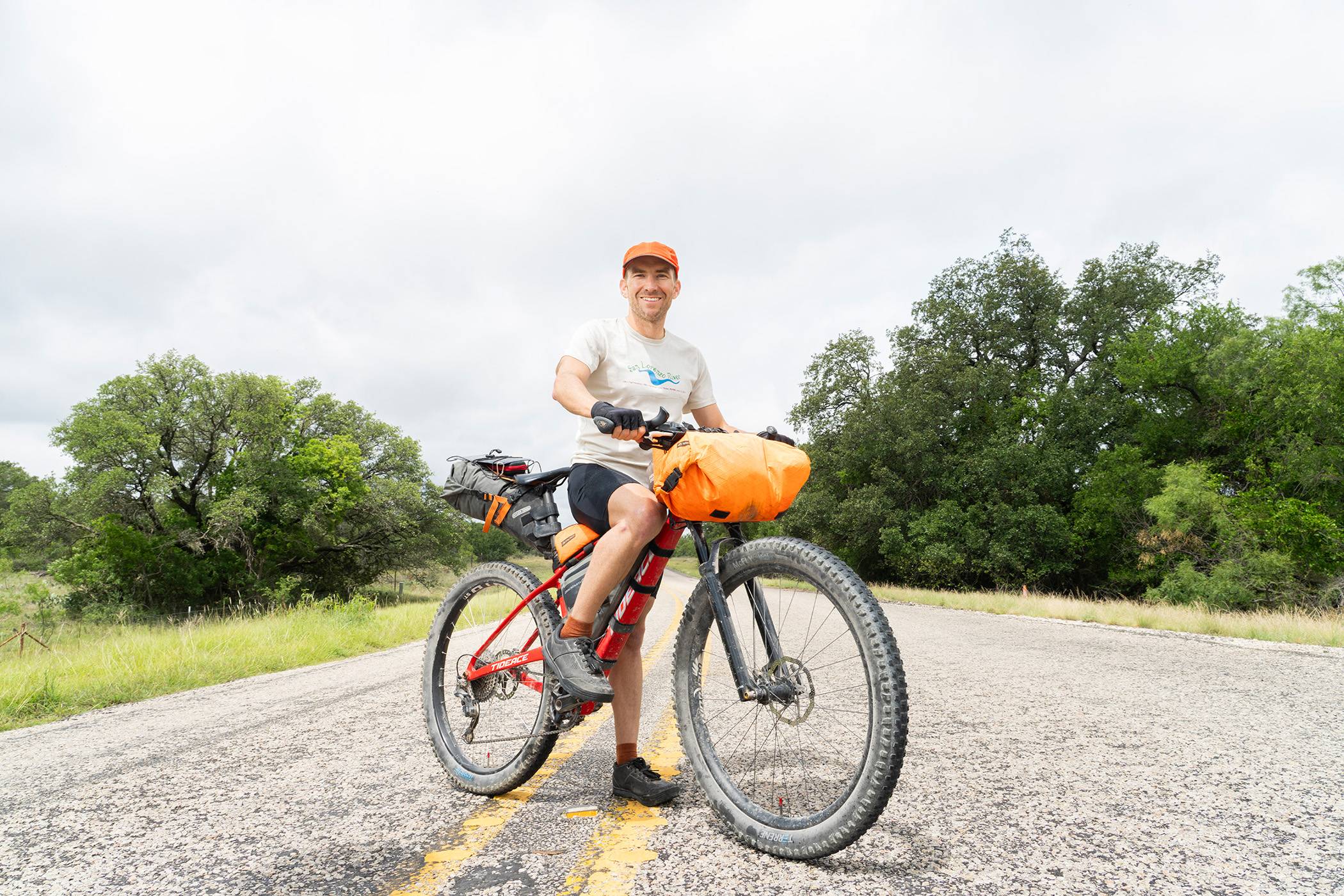 Rob Landauer grins for a portrait on his bike before he begins his next adventure.