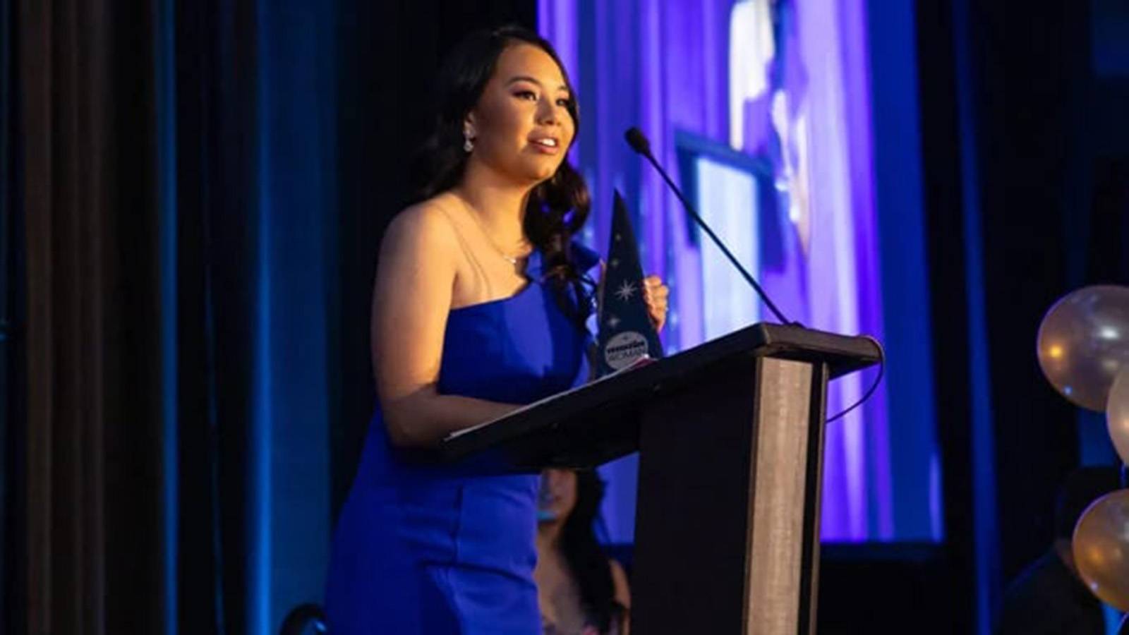 Andrea Hernandez standing at podium after receiving Rising Star Award