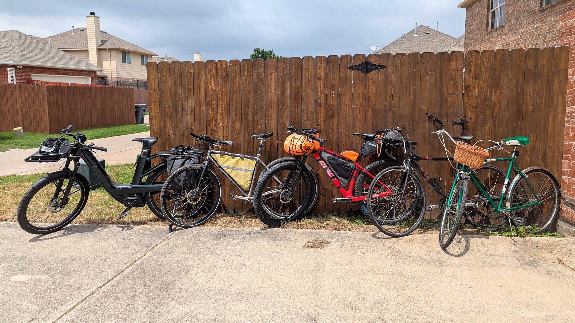 Snapshot of four of Landauer's different bicycles leaning against a fence.
