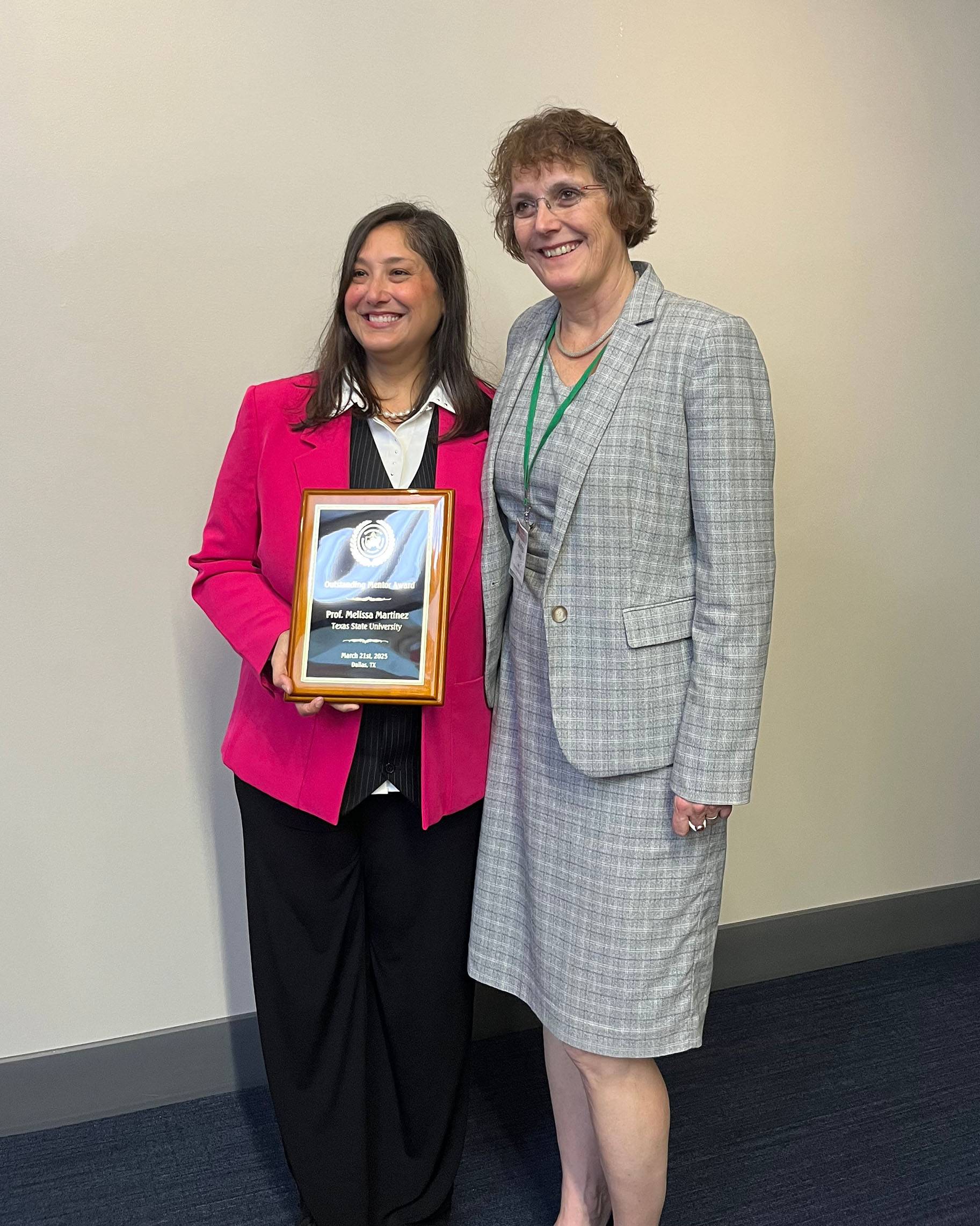 Melissa A. Martinez (left) poses for a photo with her award with Andrea Golato, Ph.D., dean of The Graduate College at TXST.