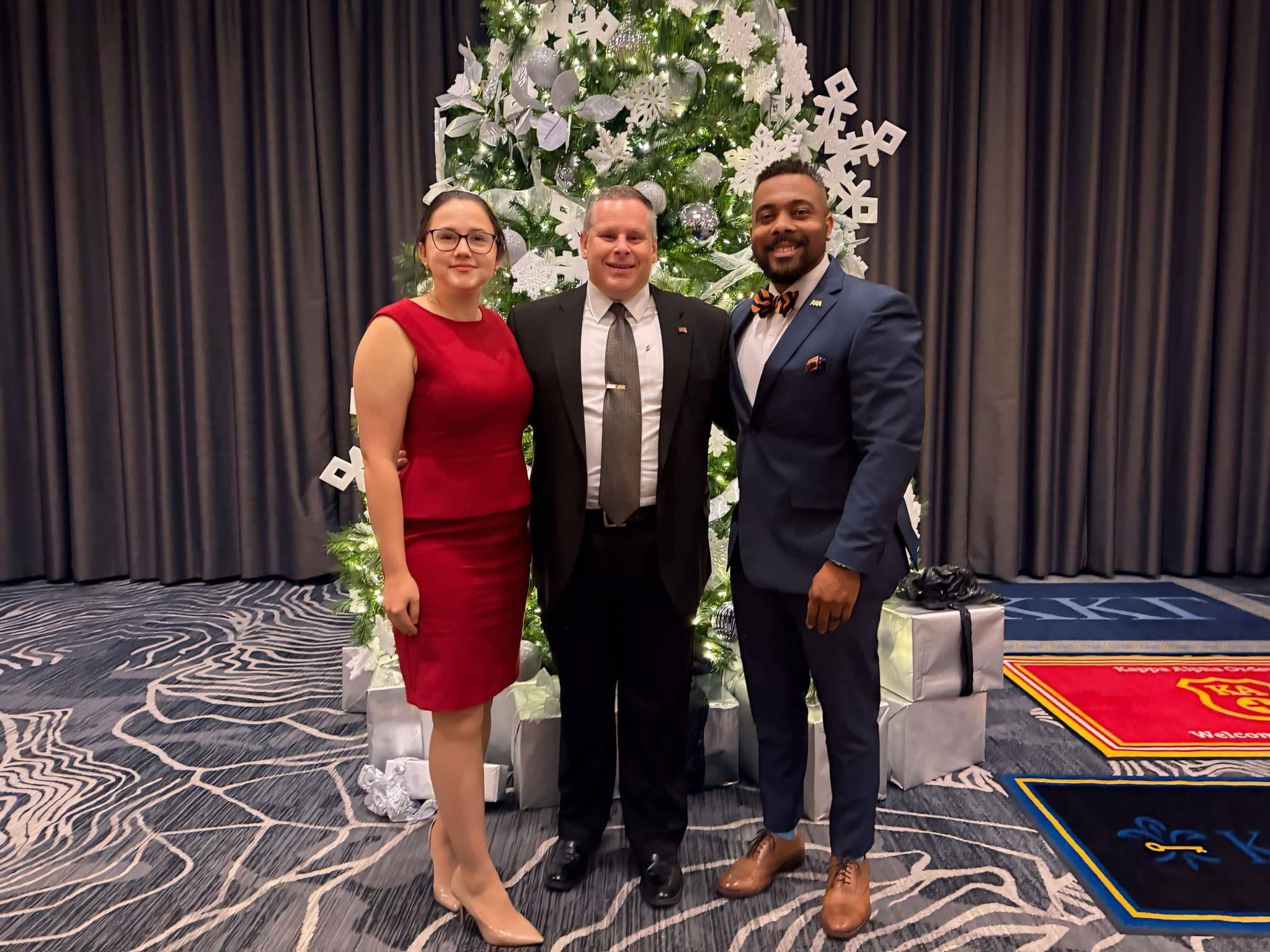 Staff standing in front of a Christmas Tree