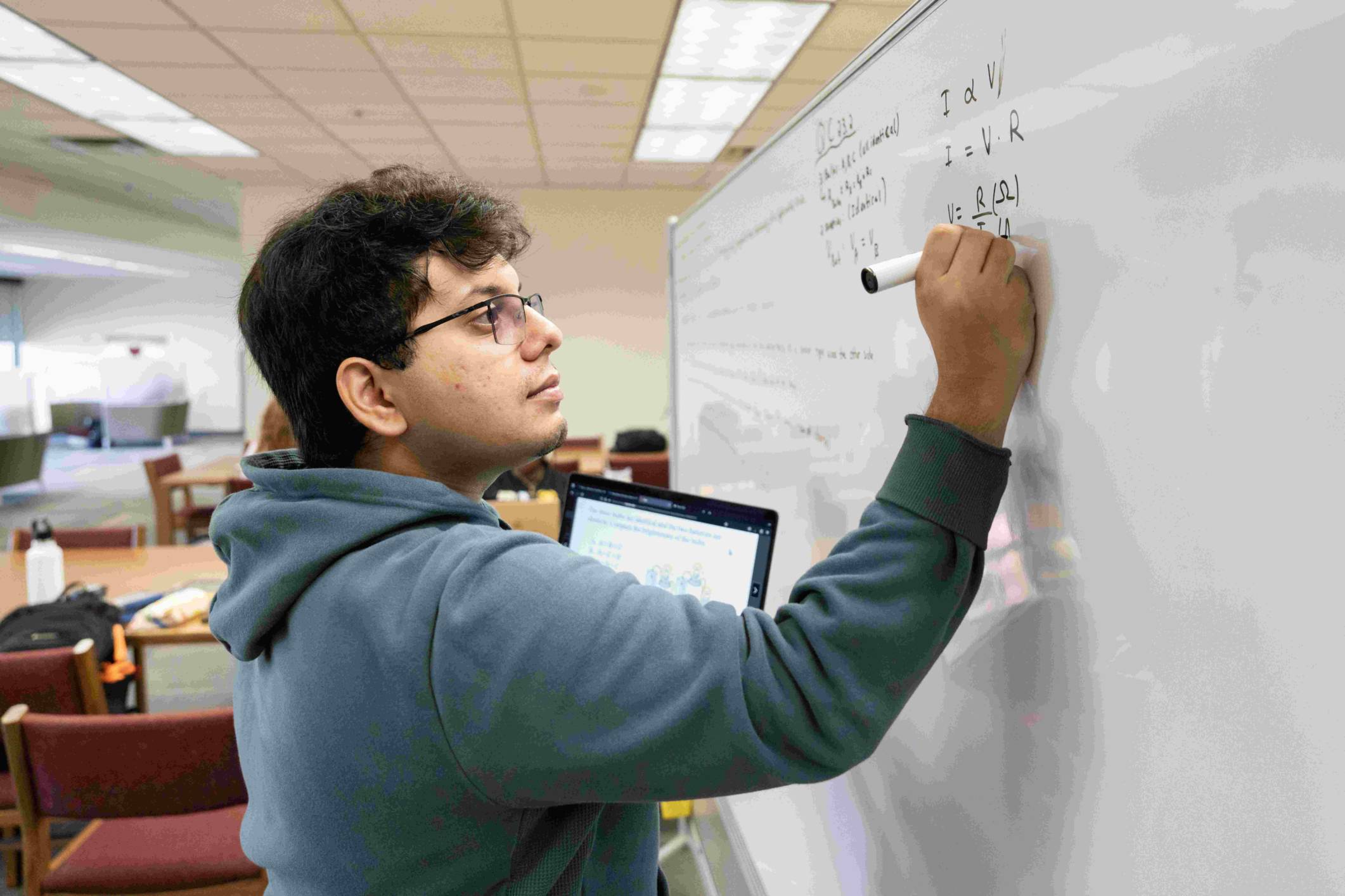 student writing on a white board