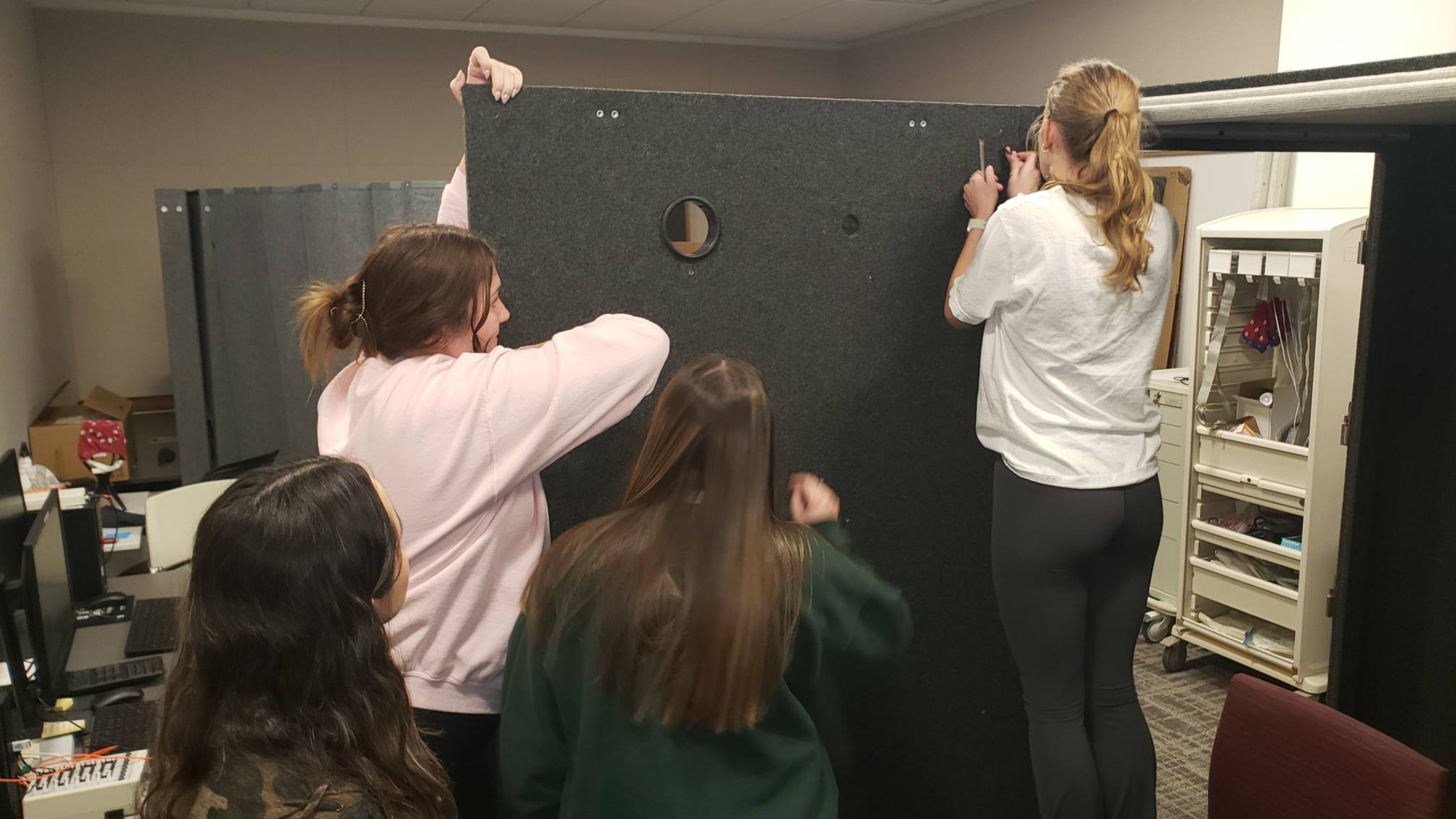 Lab members working in a booth.