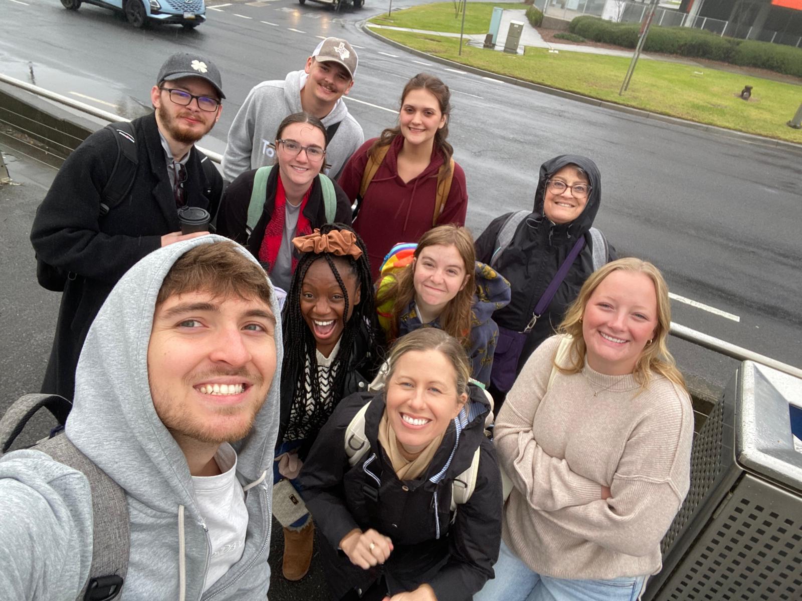 Group selfie of students waiting for tram.