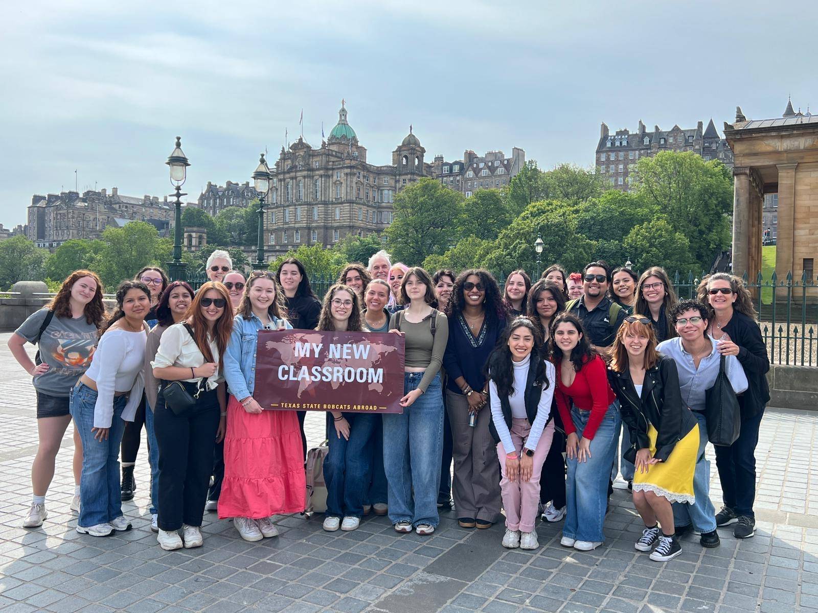Group of students posing with Texas State banner in Edinburgh