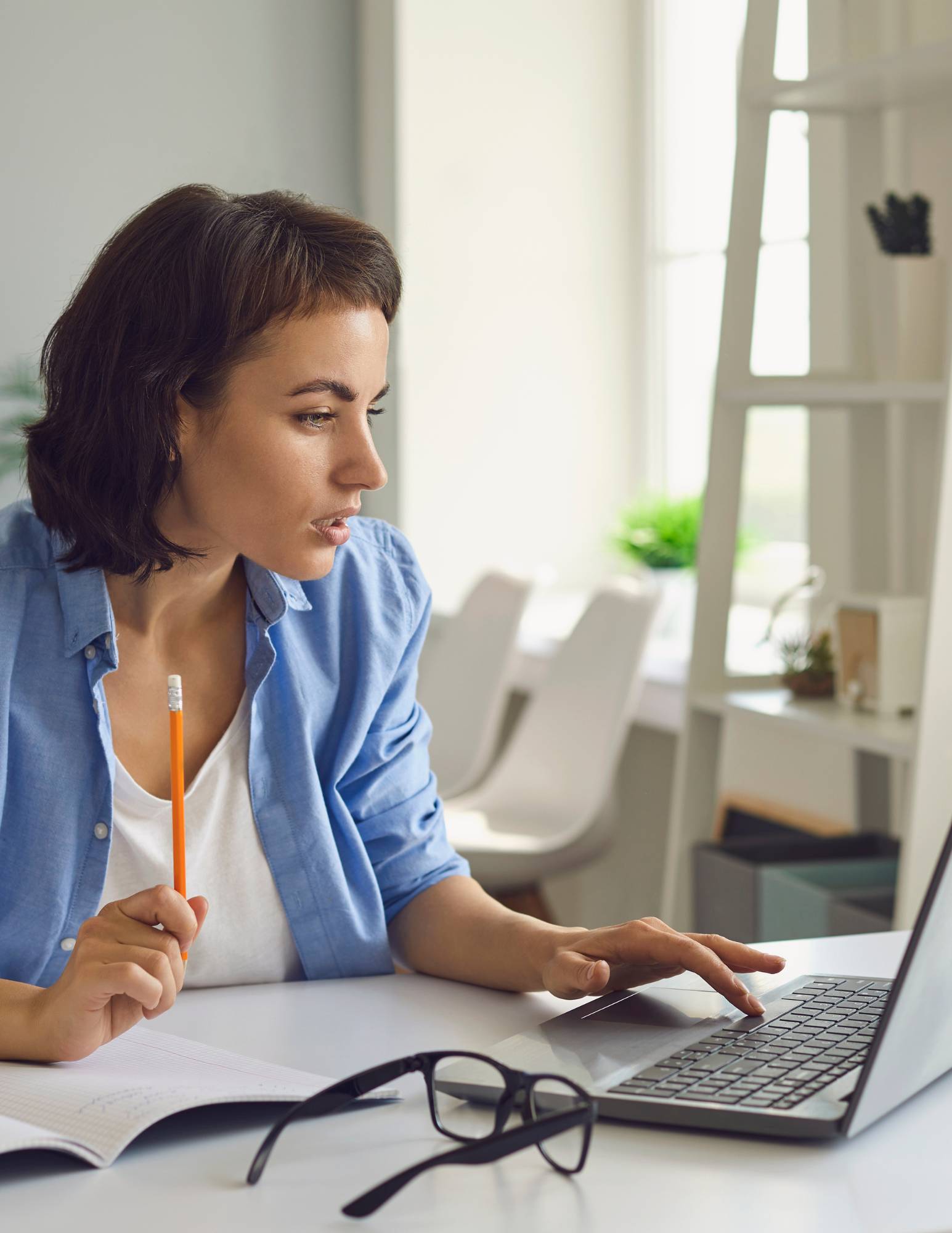 A woman sitting at a desk working on a laptop computer