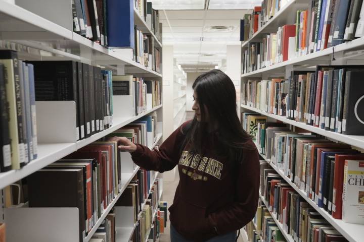 student looking for a book in the book racks