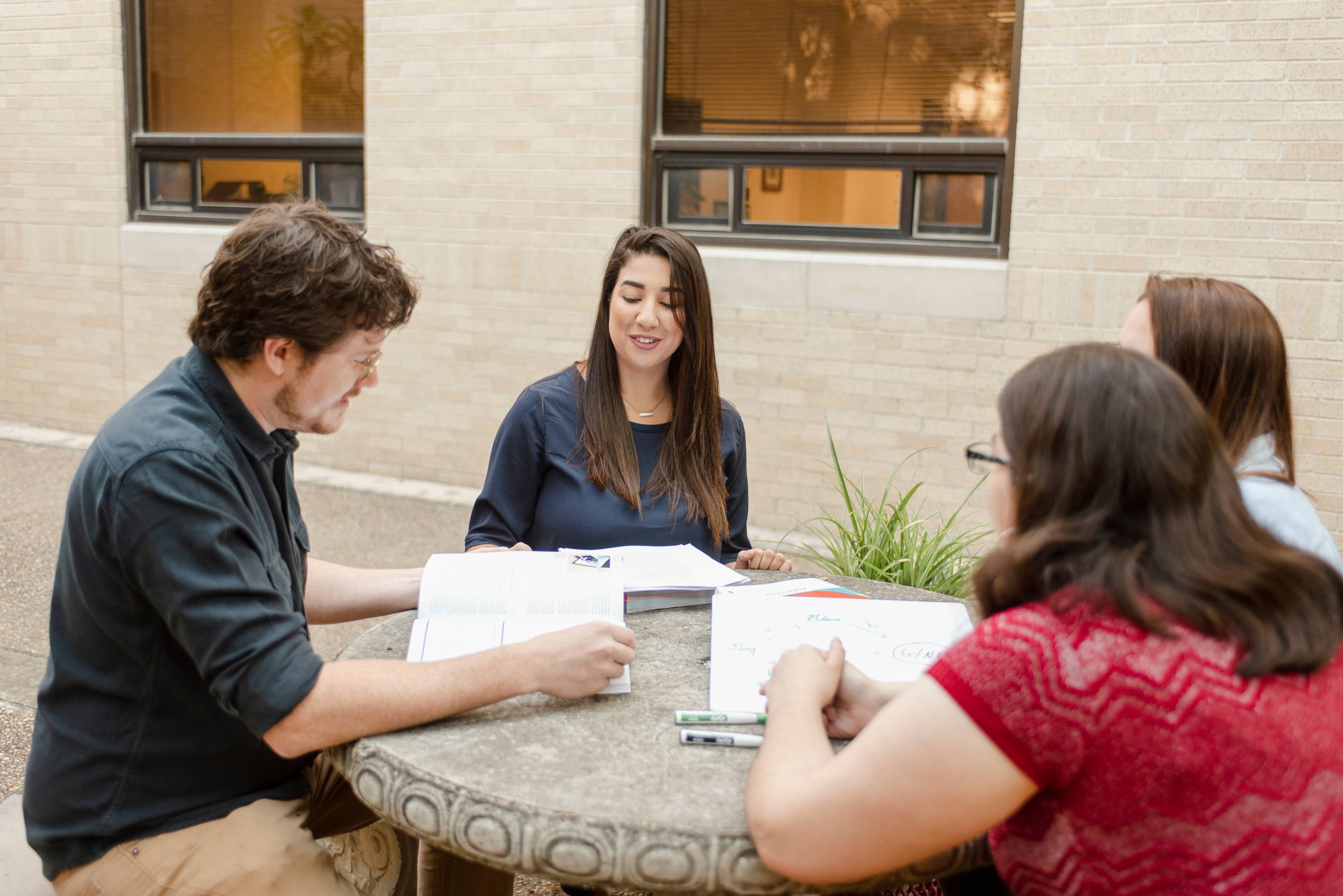 People gathered around at a table discussing a topic.
