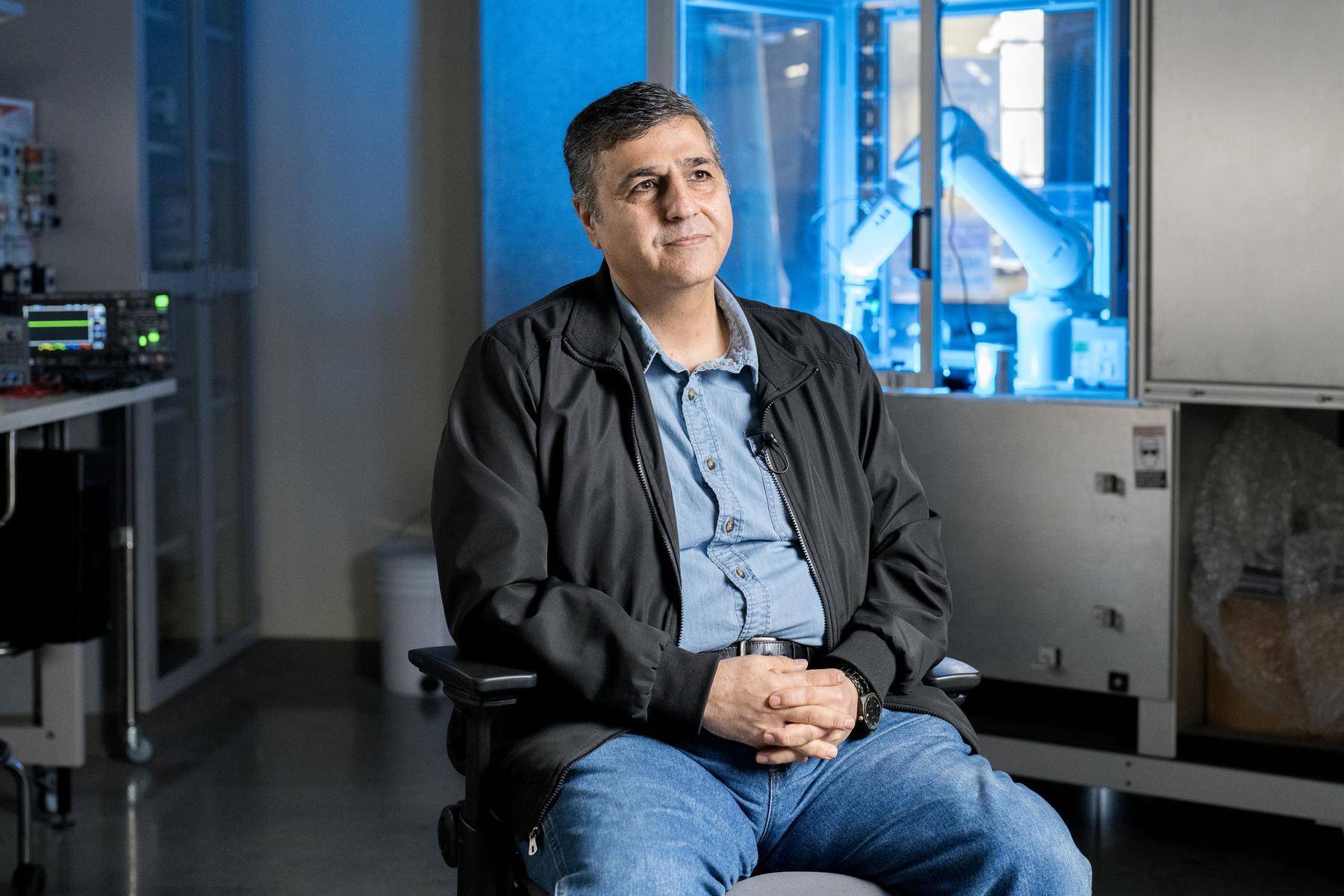 man in black jacket sitting in lab setting