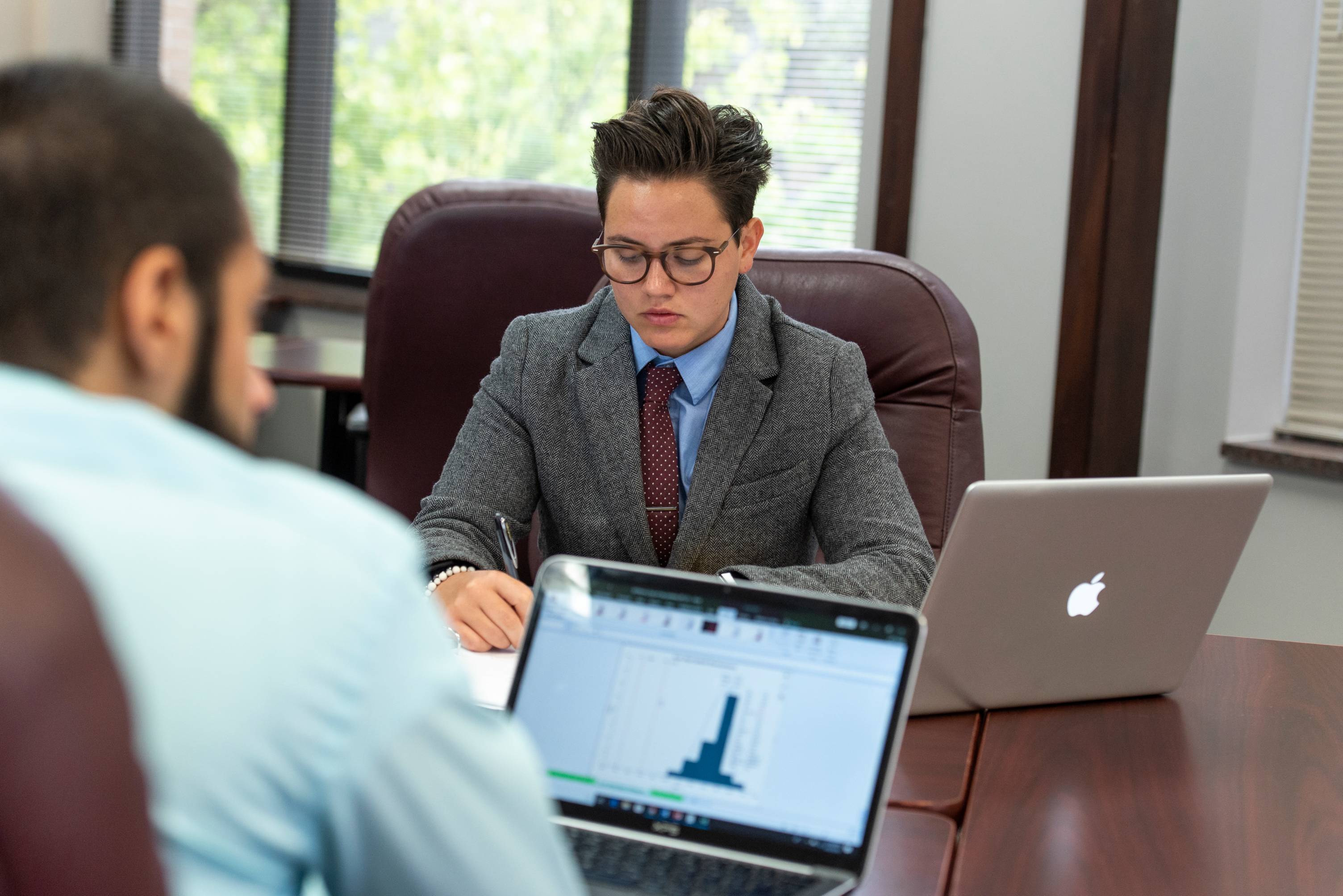 Two students sitting at a table taking notes.