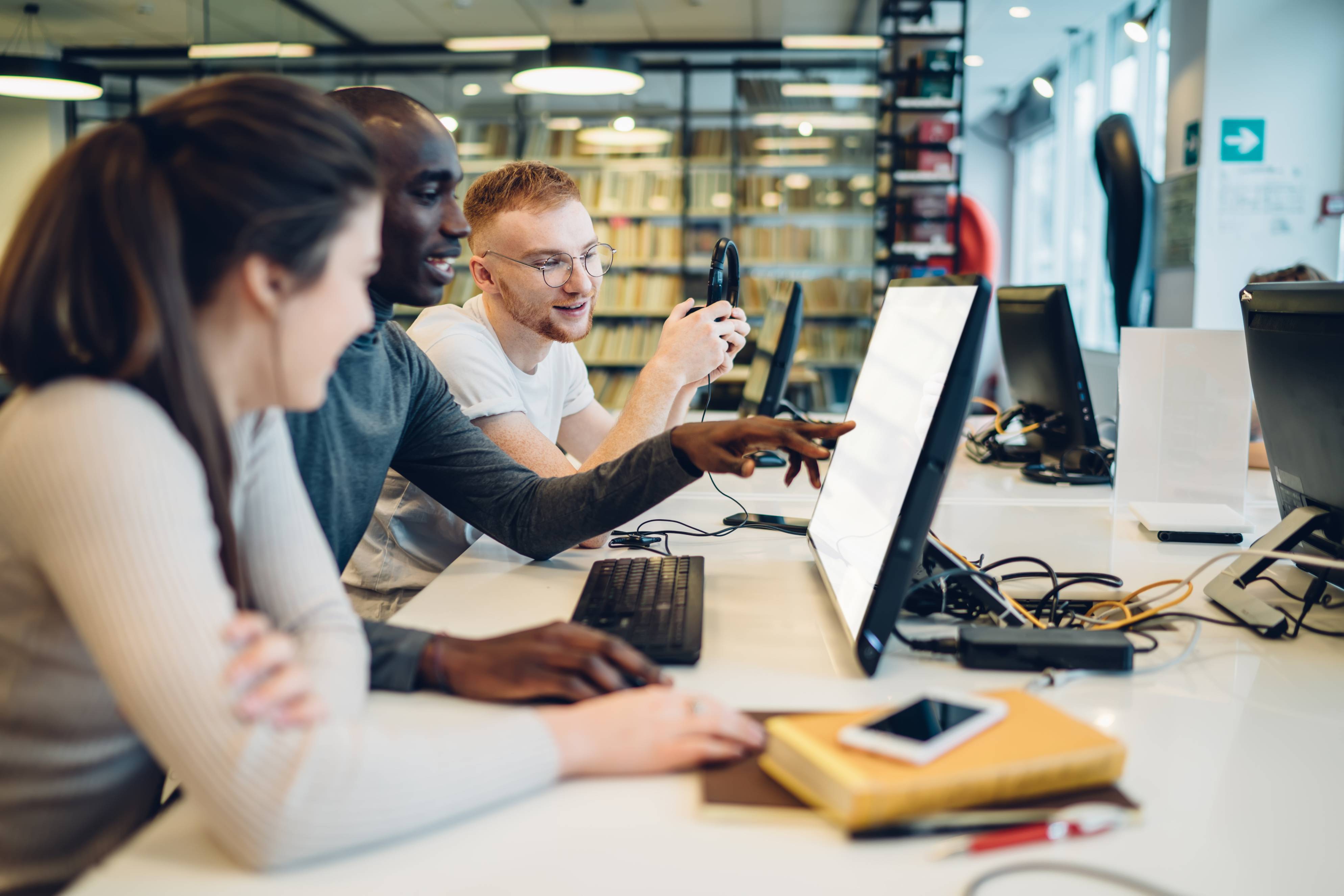 People gathered around a table looking at a computer.