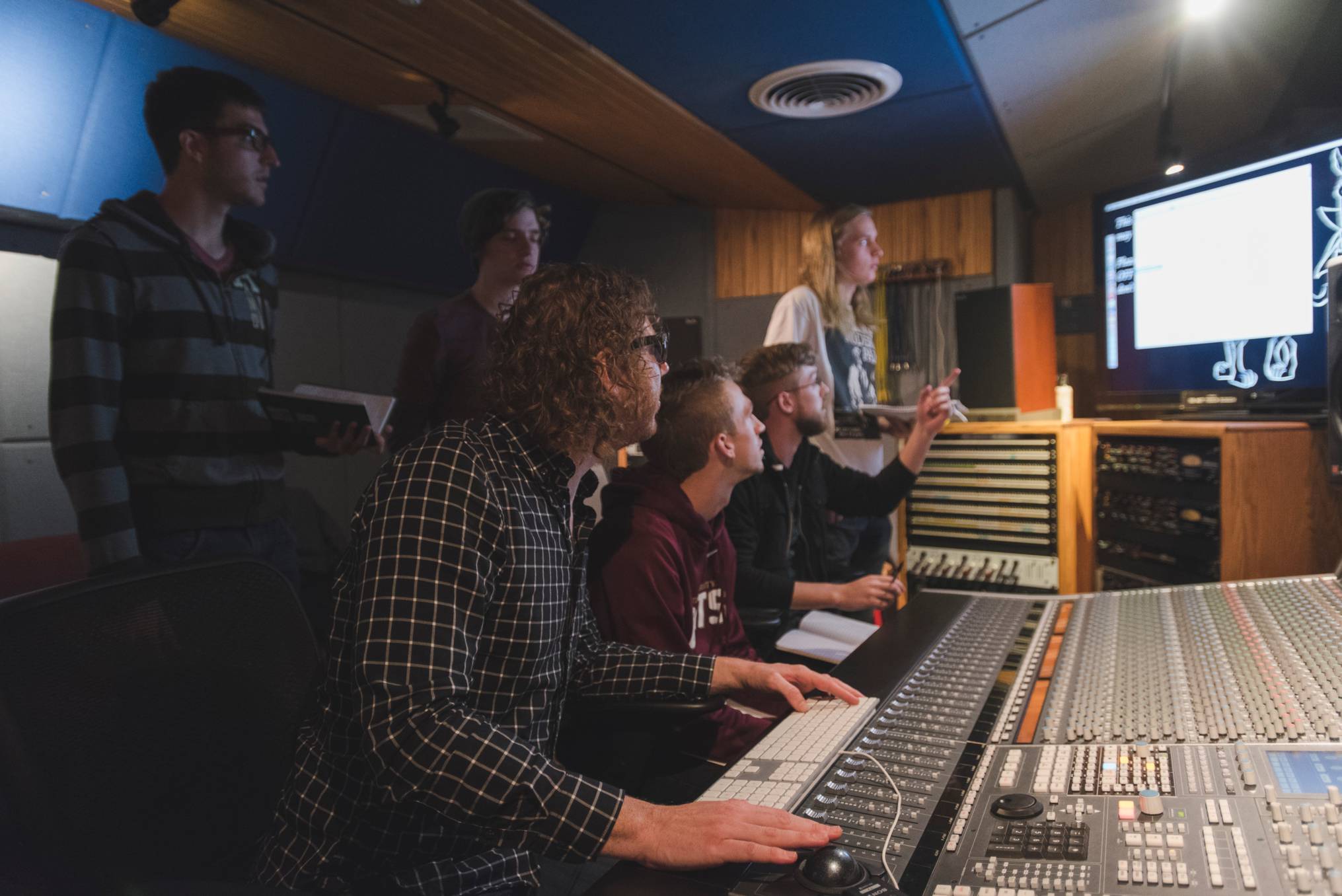 Students gathered around soundboard for class.