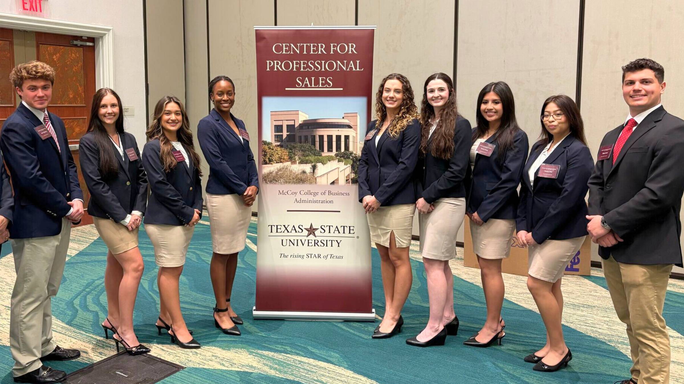 students in business professional smiling for a photo