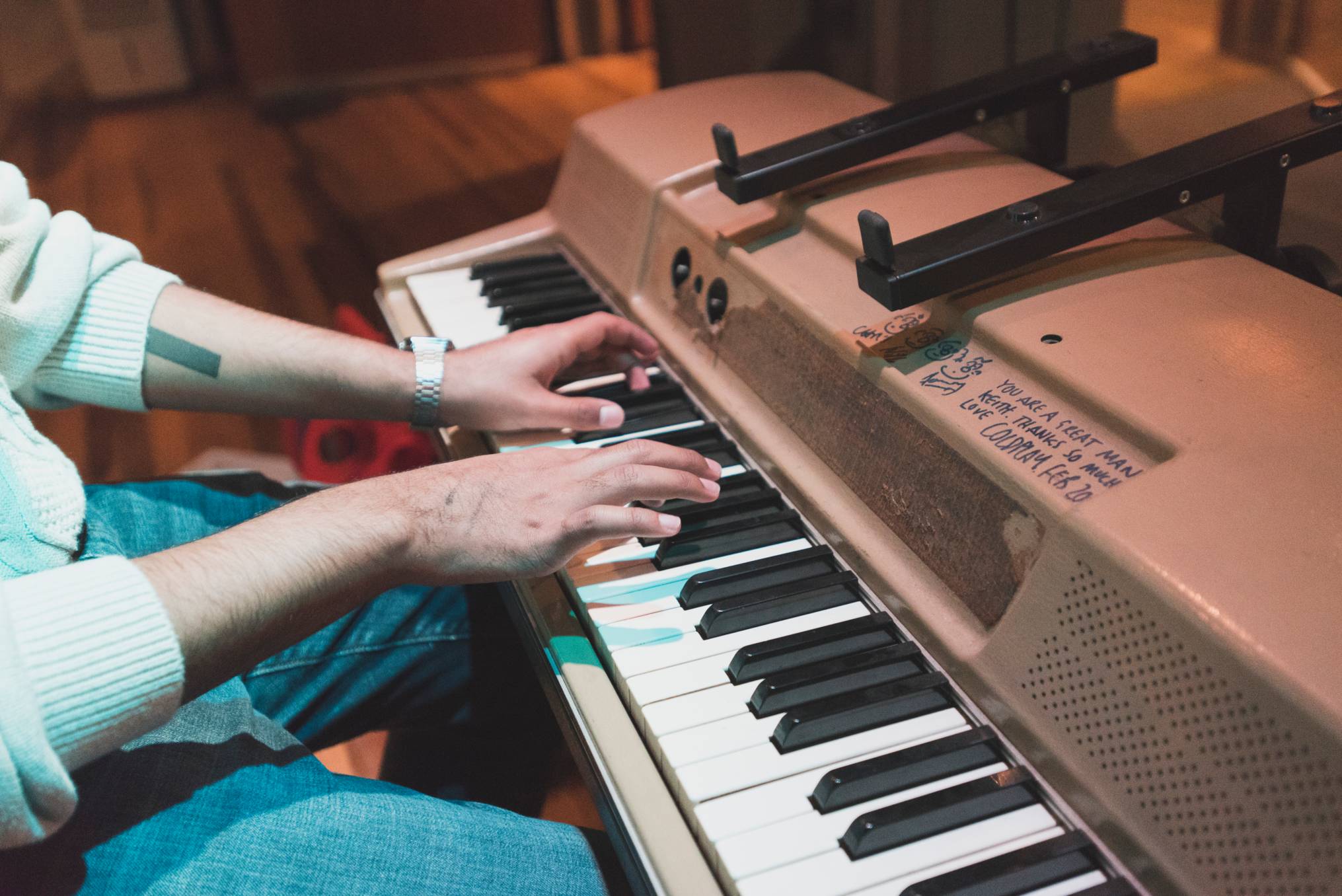 Person playing a piano in a room. 