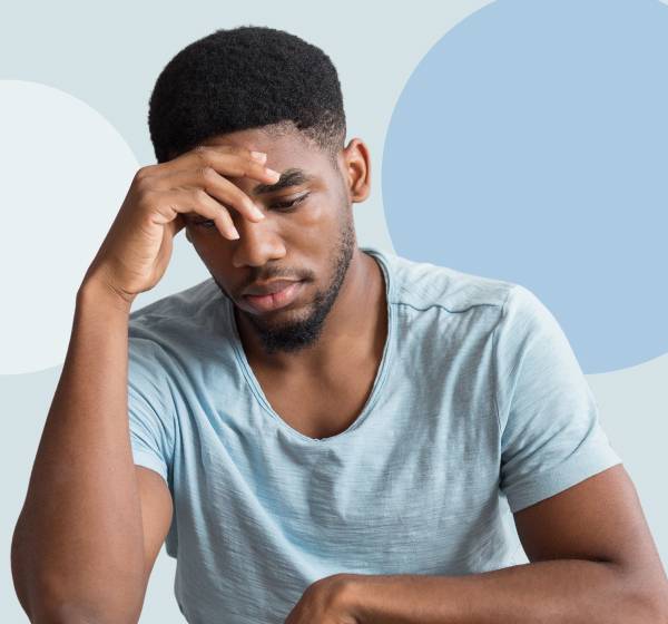 person with hand to head in sadness