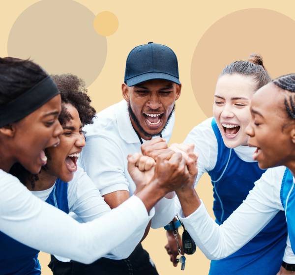 Group of five people celebrating together with hands in a circle