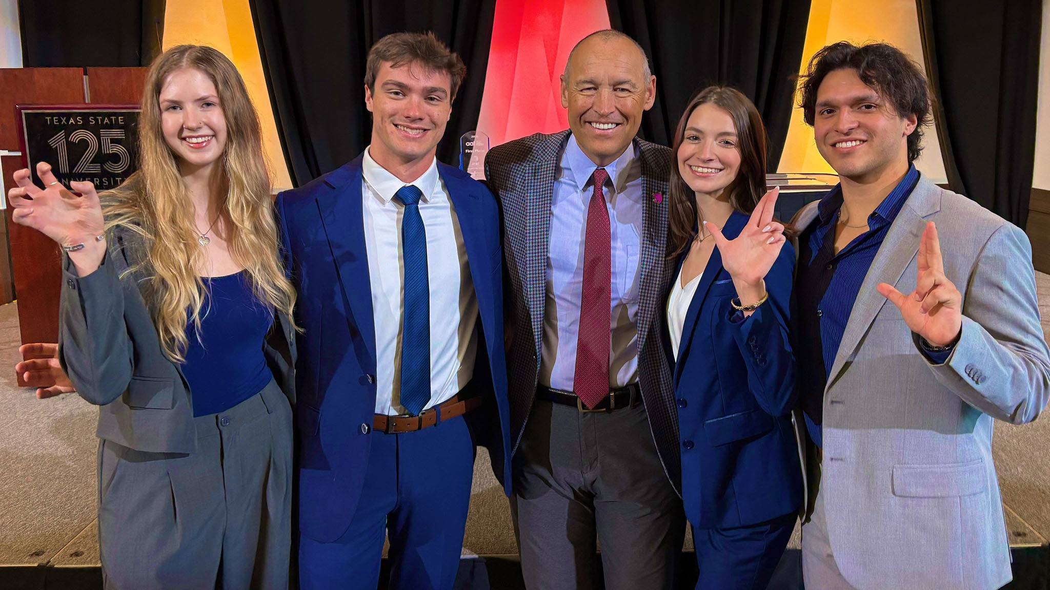 President Kelly Damphousse (middle) poses for a photo with advertising students.