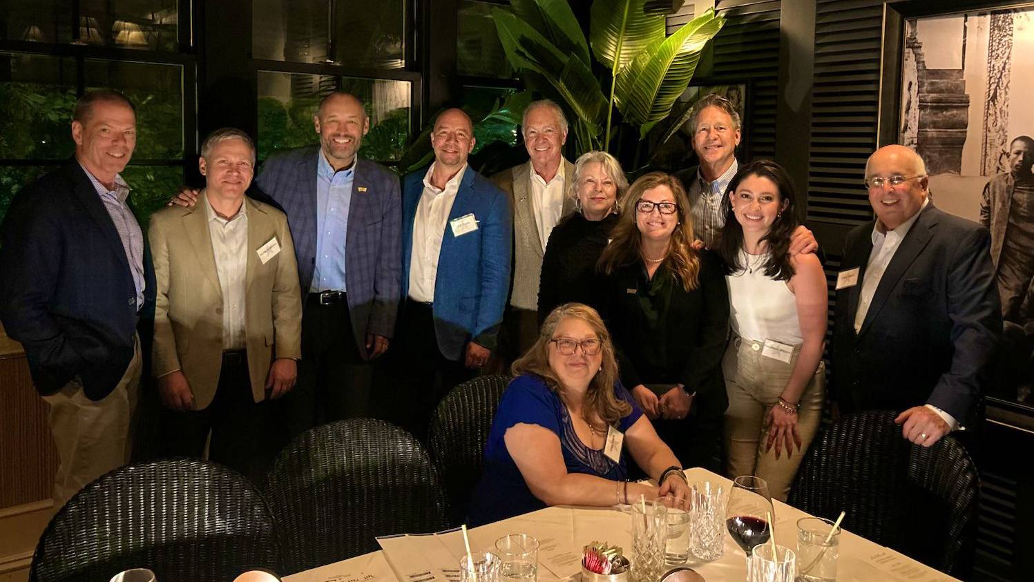 President Kelly Damphousse (third left) poses for a photo with Atlanta alumni at dinner.