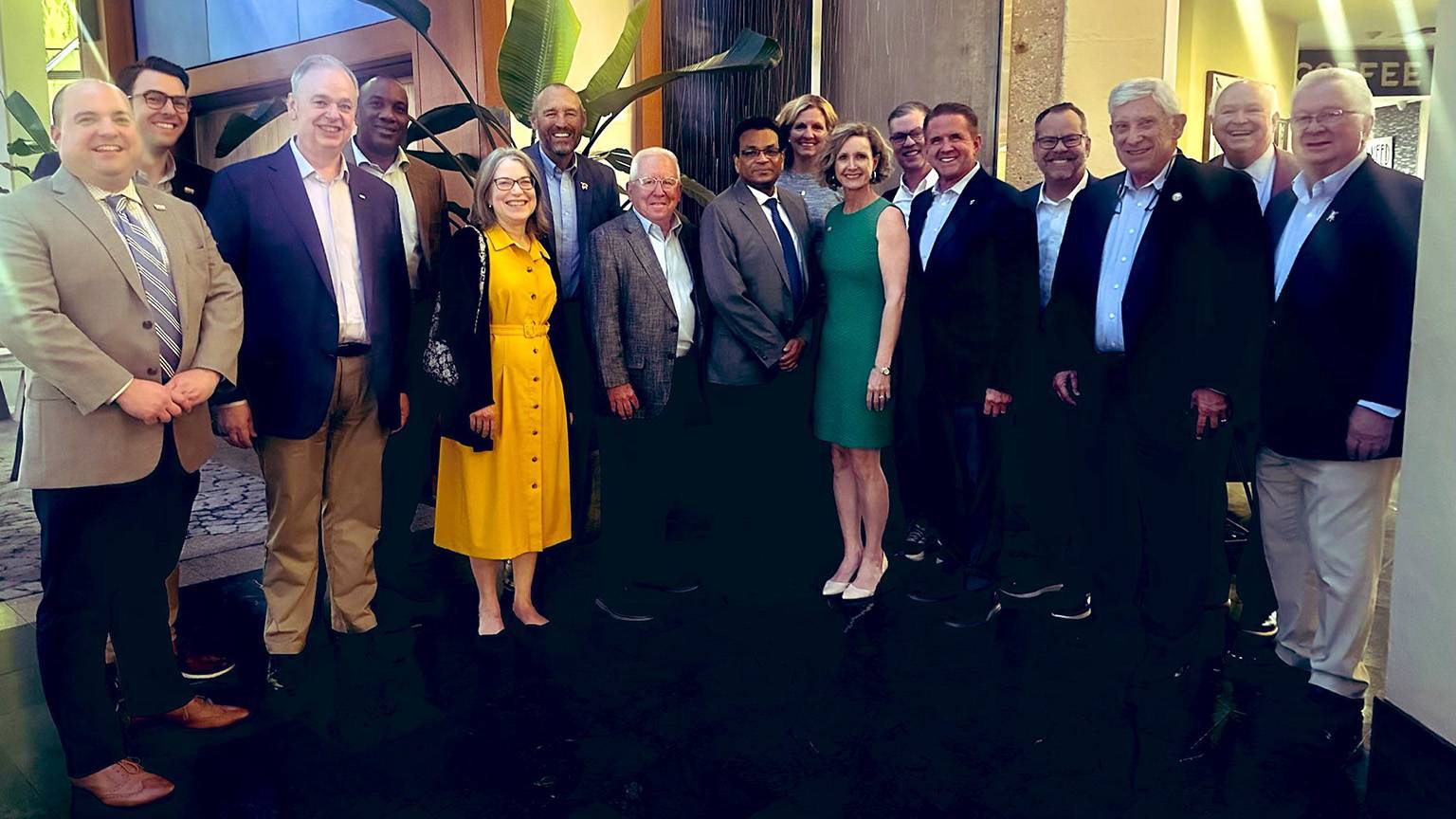 President Kelly Damphousse (back left) poses for a photo with a large group of Sun Belt Conference board members.
