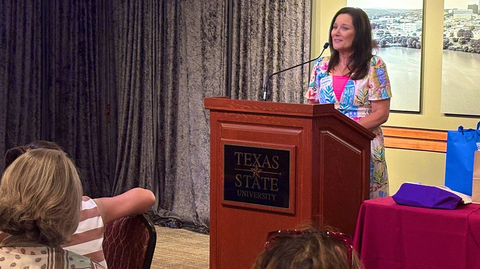 First Lady Beth Damphousse speaks to a group of people.