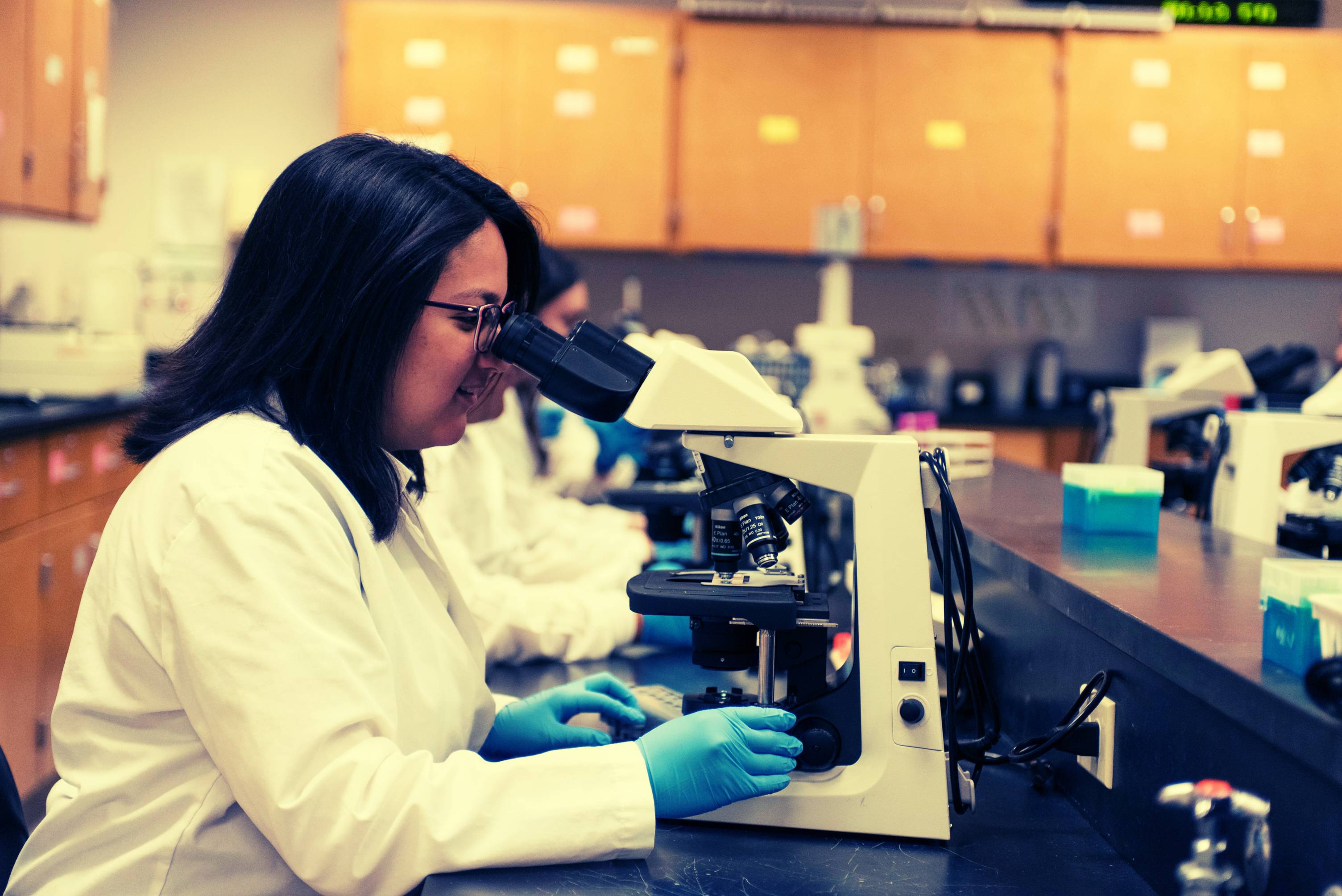 student looking at microscope
