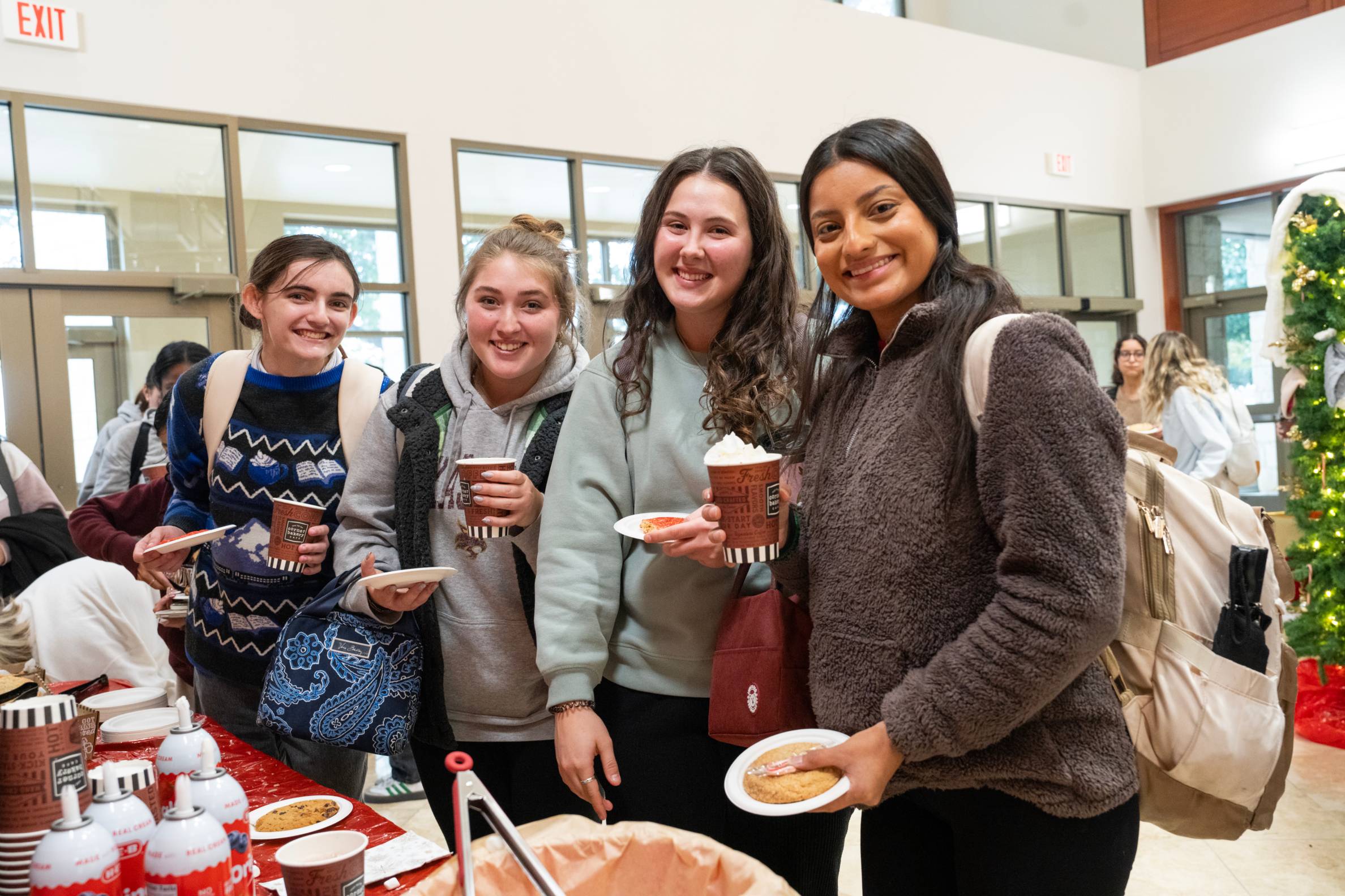 four students getting hot coco