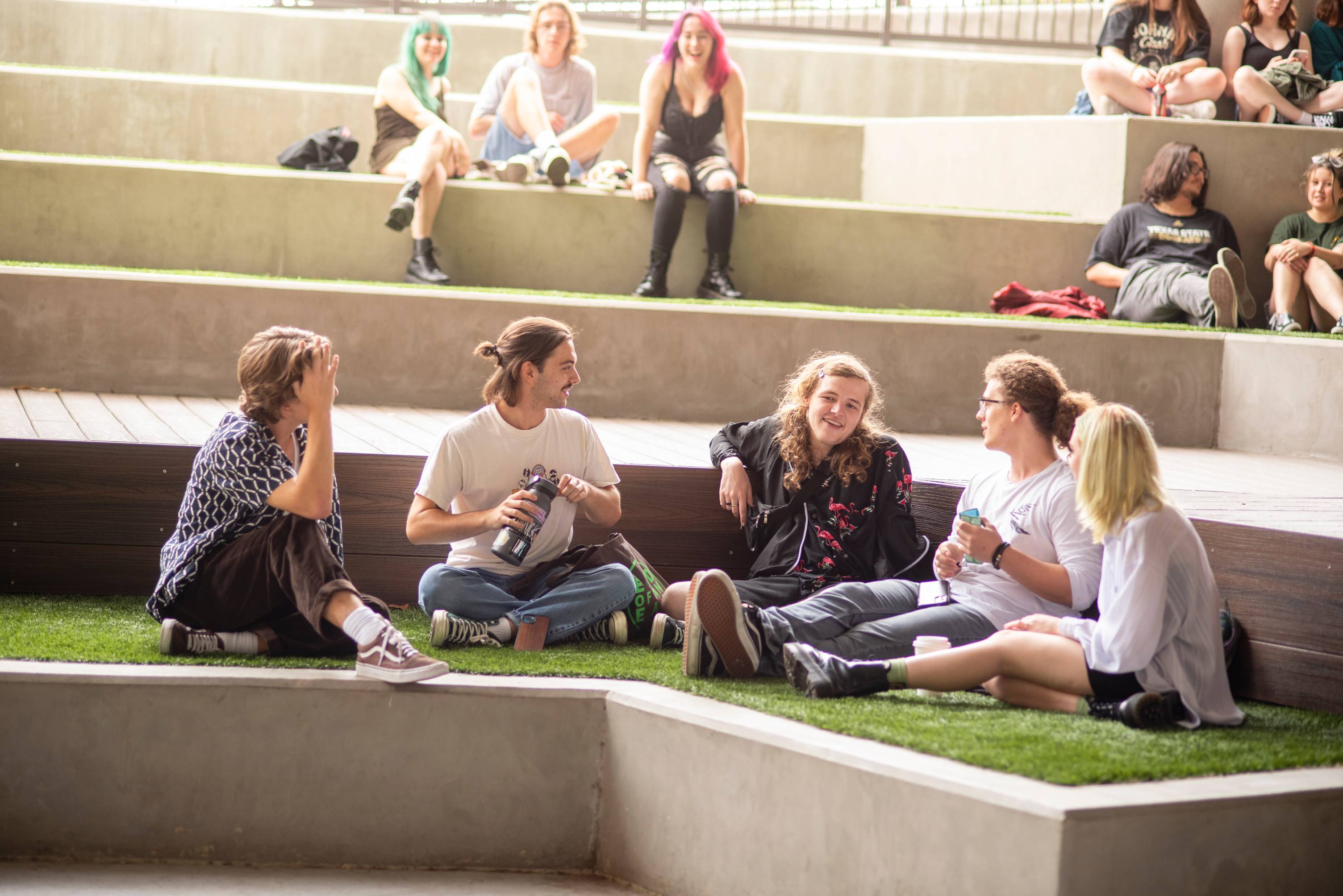 people sitting on grass laughing and talking